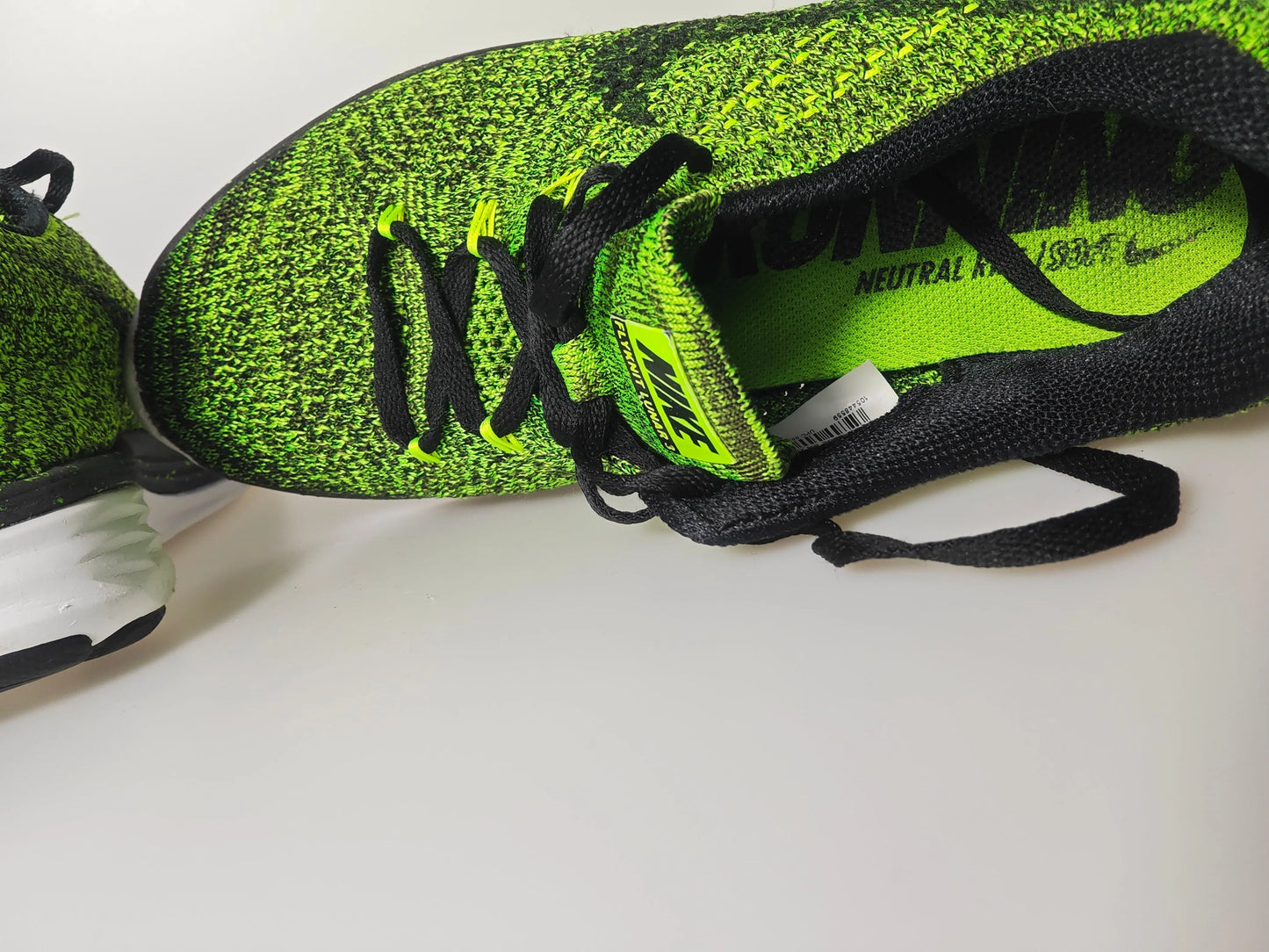 Basket Flyknit vert et noir de Nike, avec lacets noirs et semelle intérieure vert vif.