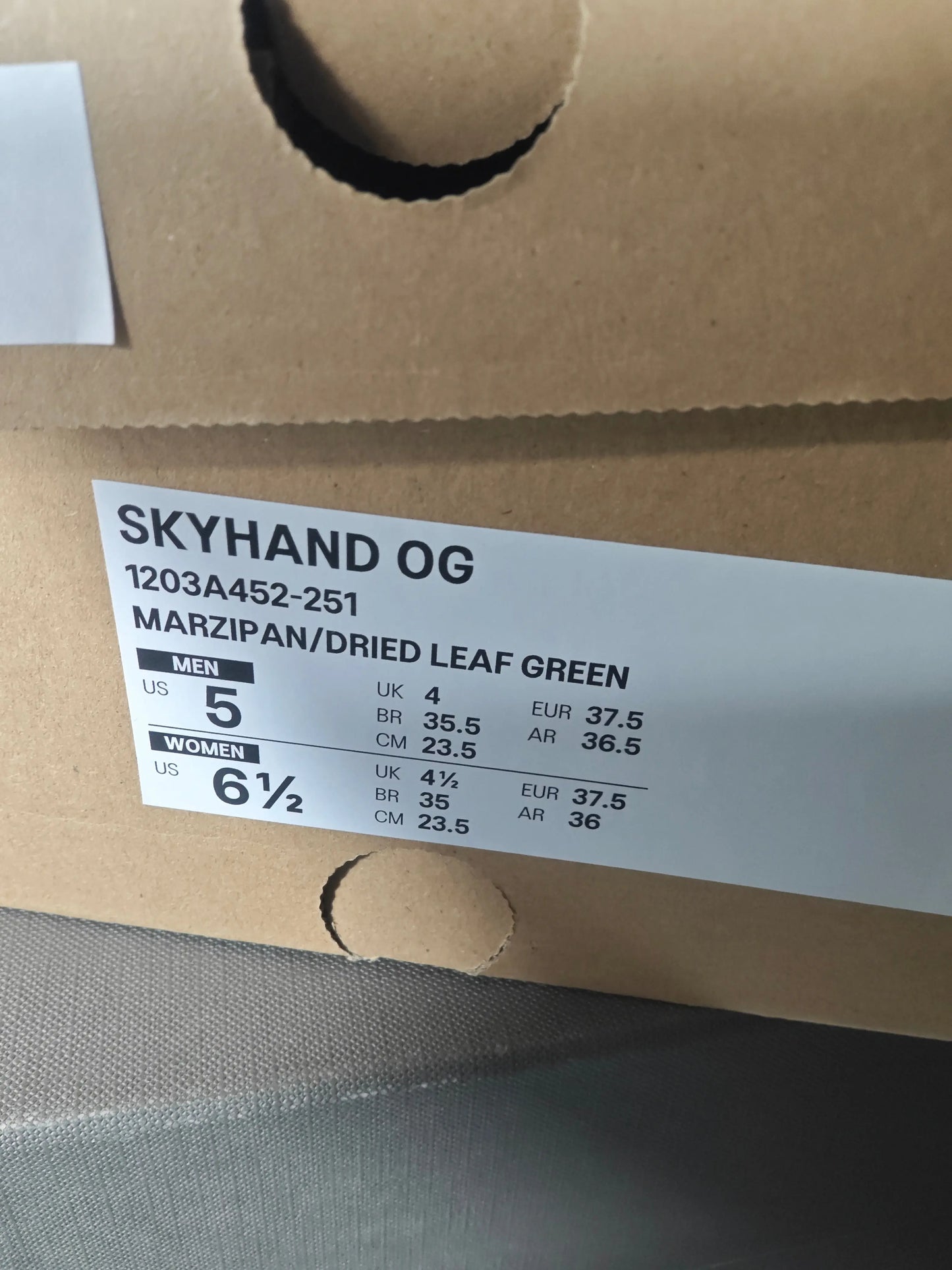 Basket Skyhand OG couleur marzipan et feuille verte séchée de Asics, montrant les informations de taille.
