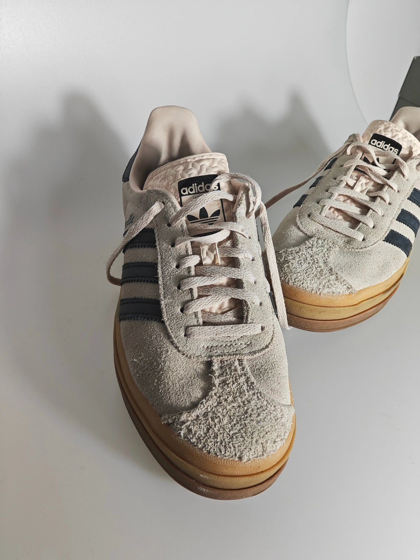 Baskets Gazelle en daim beige d'Adidas, avec triple semelle contrastée et trois bandes latérales noires.