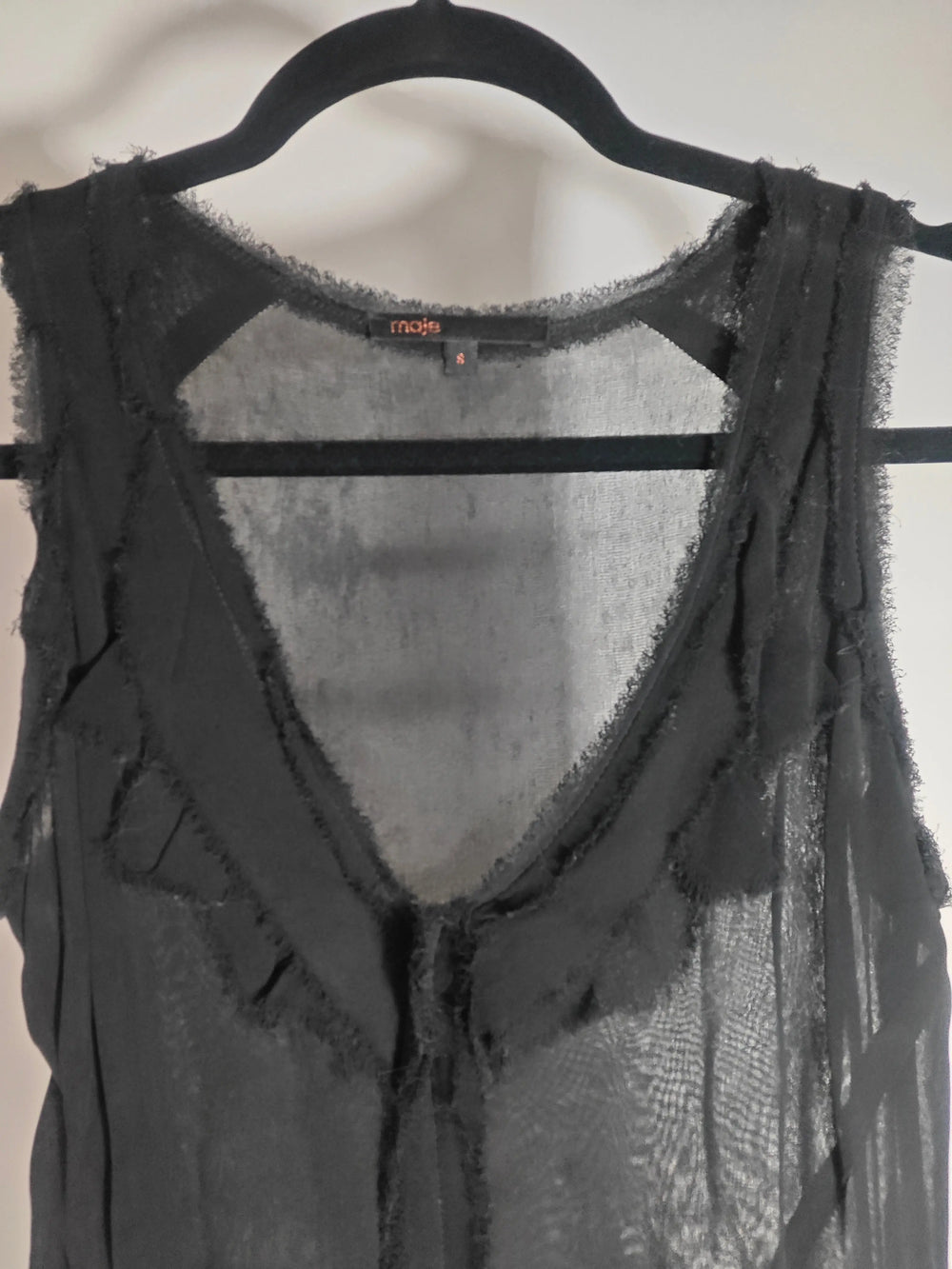 Robe noire fluide de Maje, style bohème chic avec détails de volants frangés.
