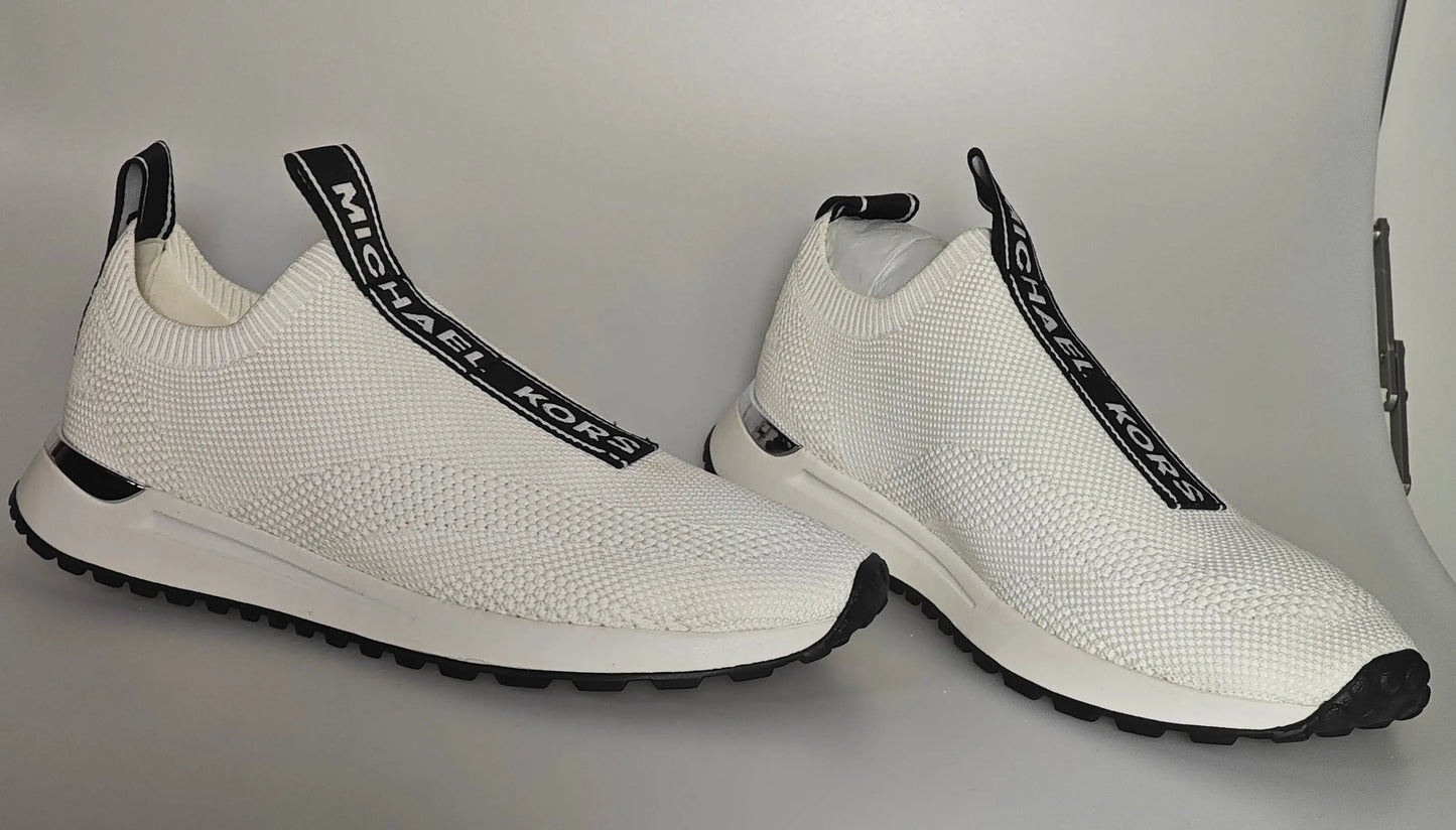 Baskets blanches en maille extensible de Michael Kors avec des accents noirs et une semelle blanche.