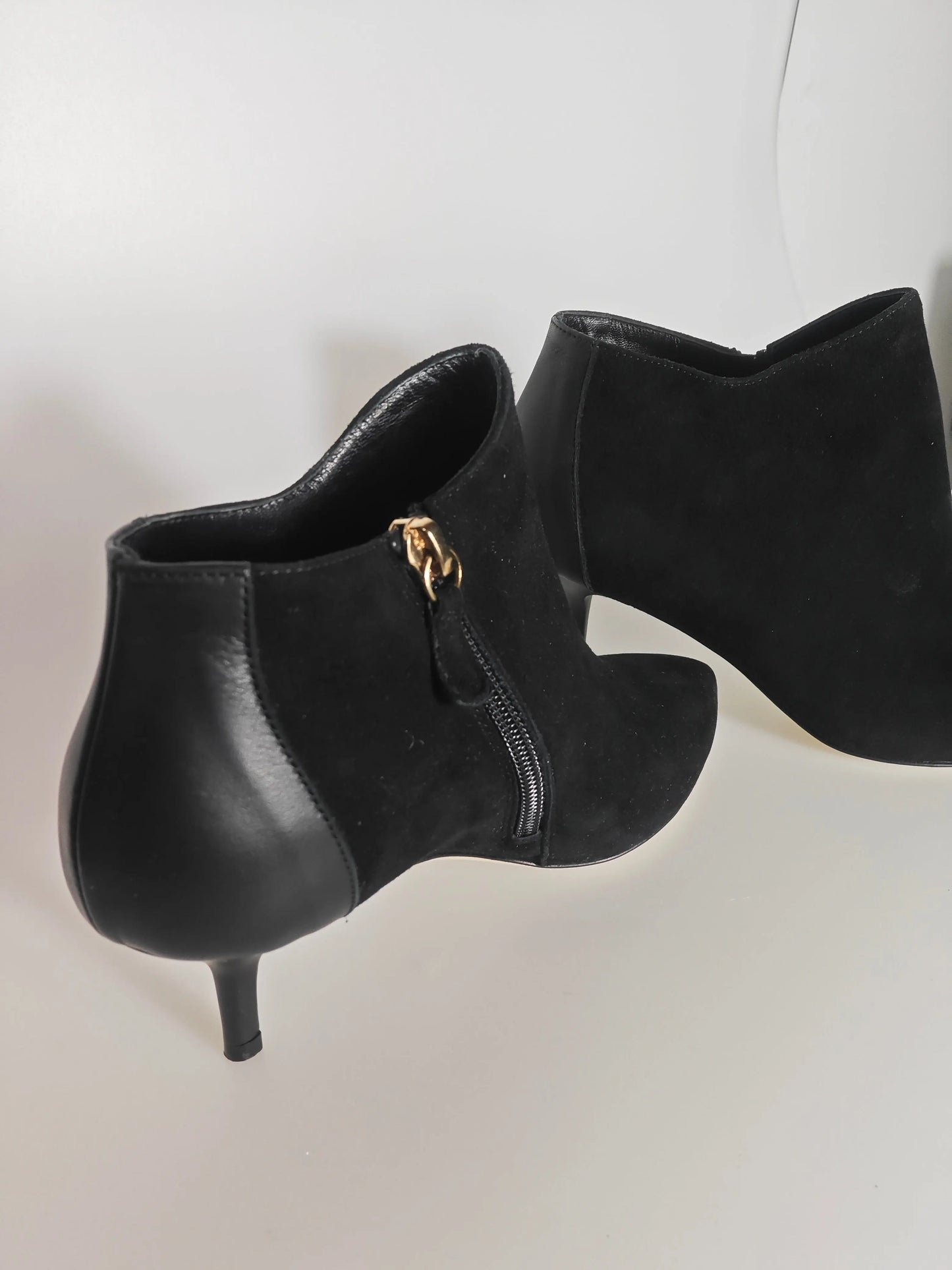 Bottines en daim noir de Repetto, avec fermeture éclair dorée sur le côté et talon aiguille.