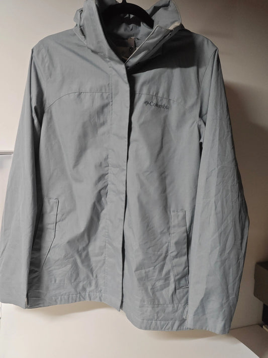 Veste de pluie bleue Columbia en excellent état, avec capuche et poches, suspendue à un cintre.