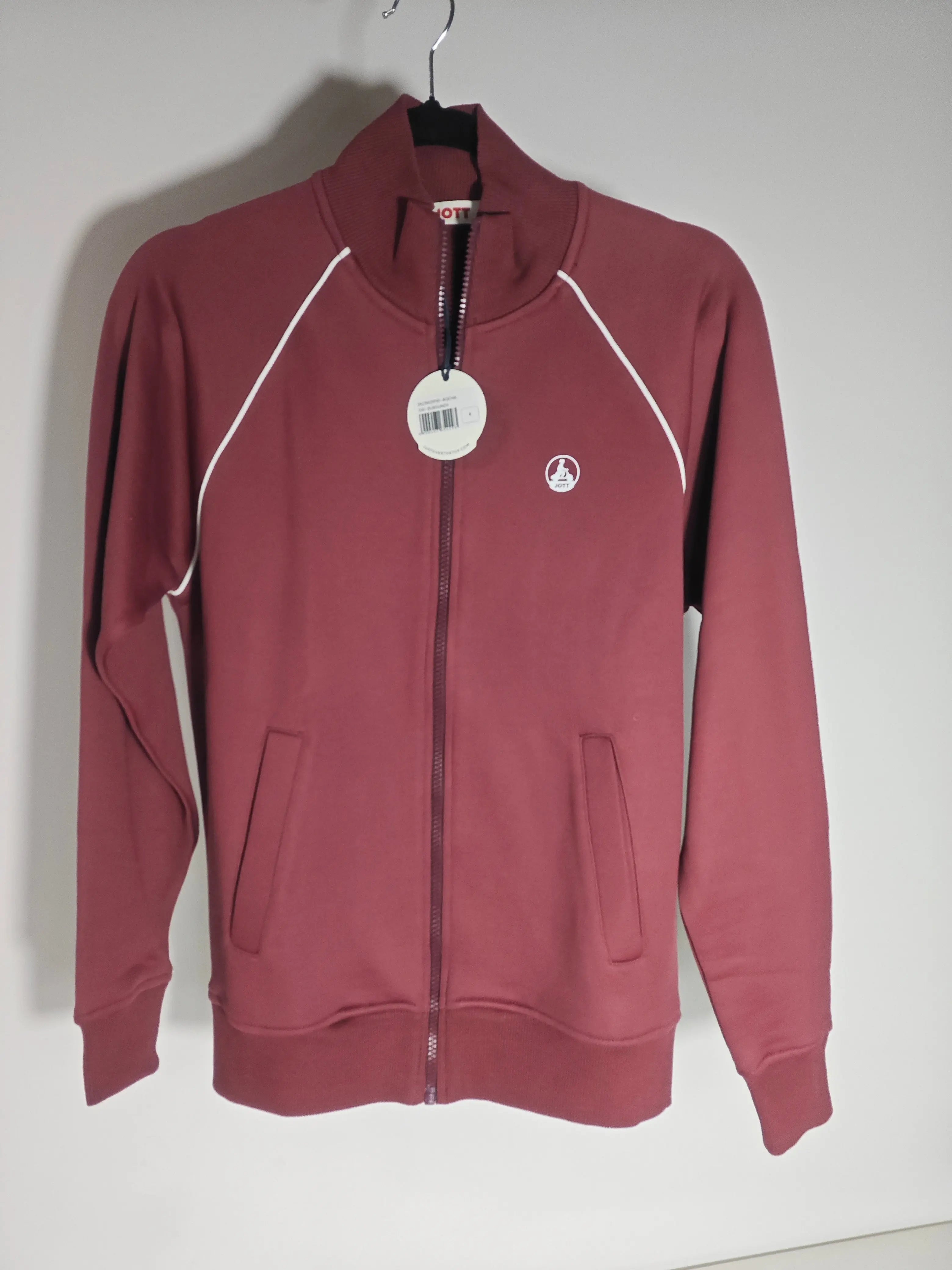 Sweat zippé bordeaux de Jott, avec des bordures blanches sur les épaules et des poches sur le devant.