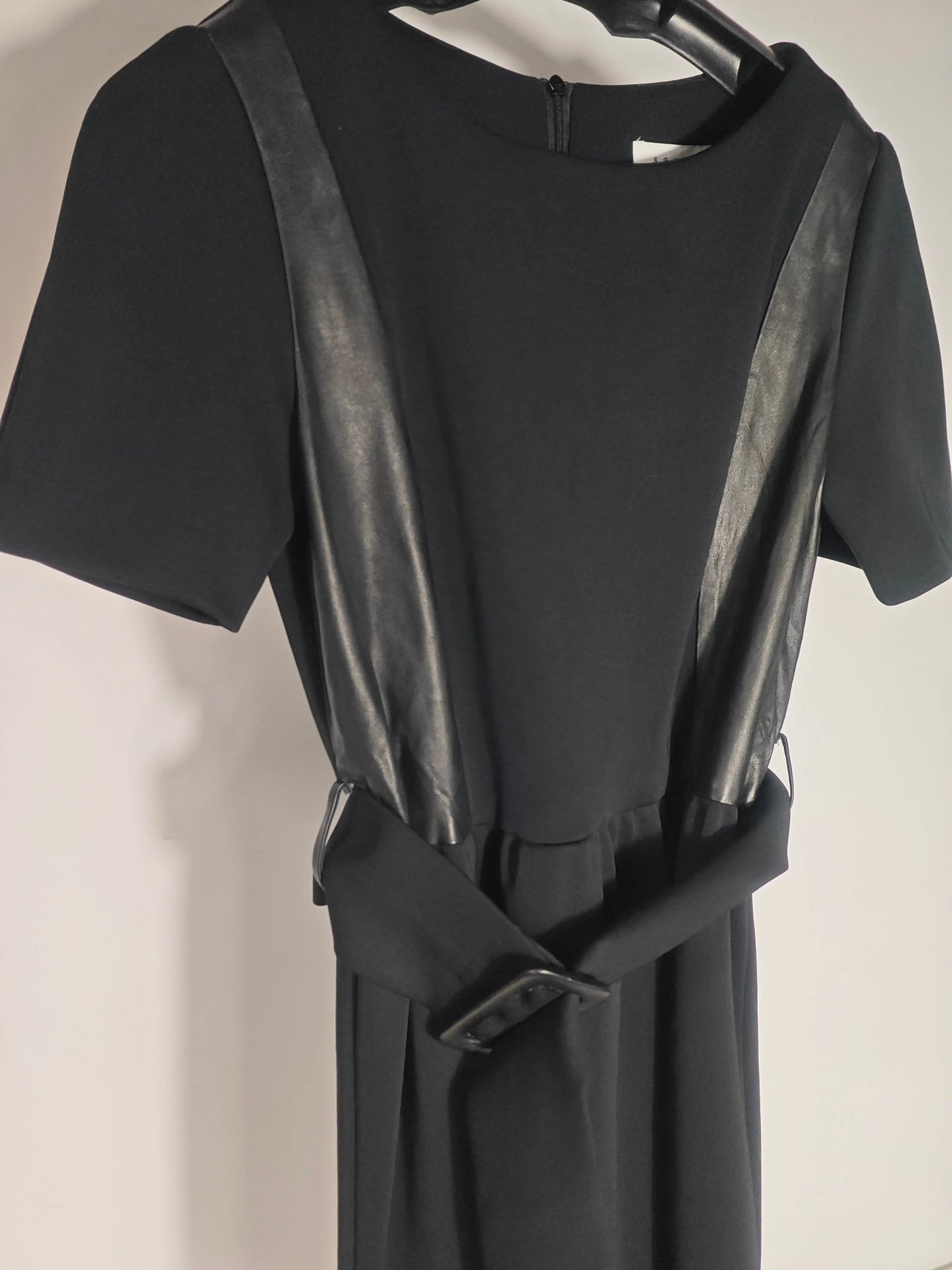 Robe noire à empiècements en similicuir de Sandro, avec ceinture à boucle.
