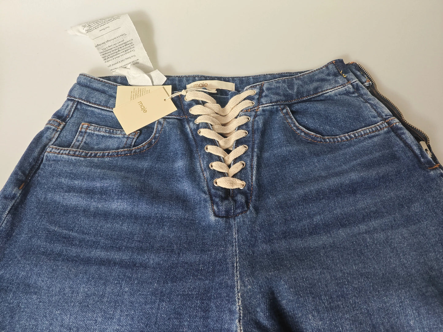 Jean bleu taille haute lacé sur le devant de Maje avec étiquettes apparentes.
