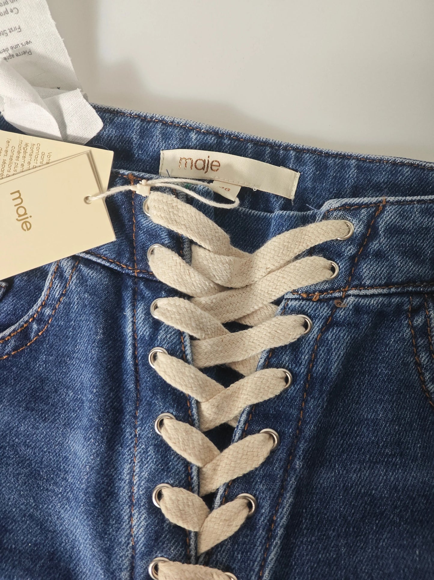 Jean bleu taille 38 lacé sur le devant par Maje, avec étiquette attachée.
