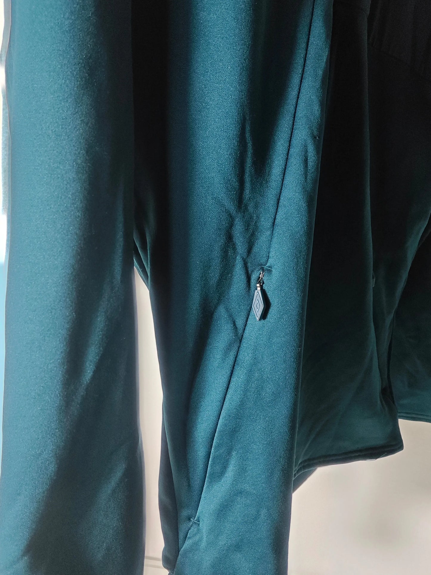 Veste vert foncé par Umbro avec une fermeture éclair sur la manche, en tissu texturé.