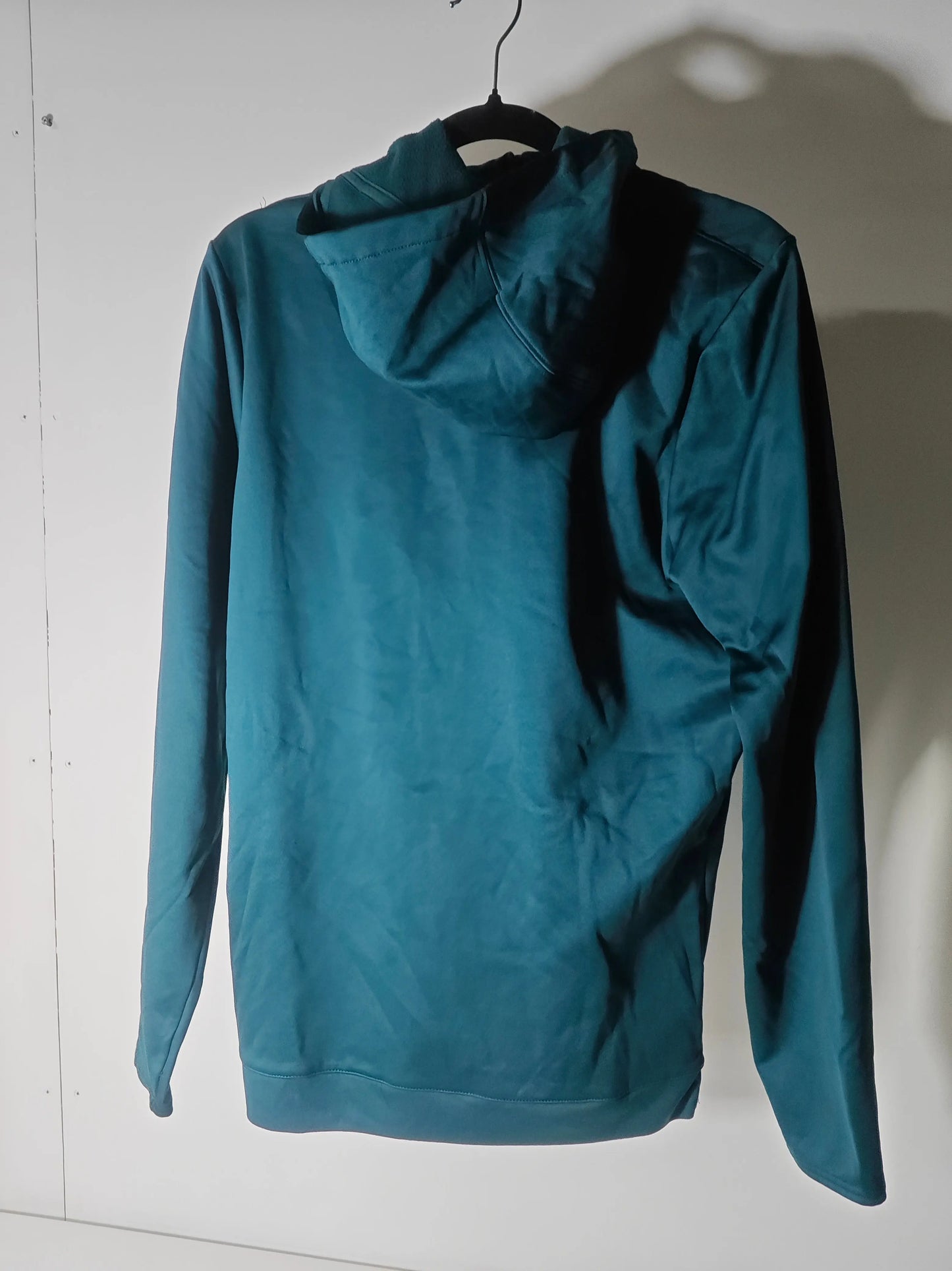 Veste bleue de Umbro, taille M, sur un cintre noir, vue de dos.
