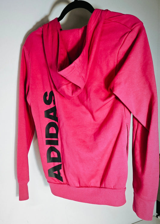 Chandail à capuchon rose fuchsia de Adidas avec le mot « ADIDAS » imprimé verticalement au dos.

