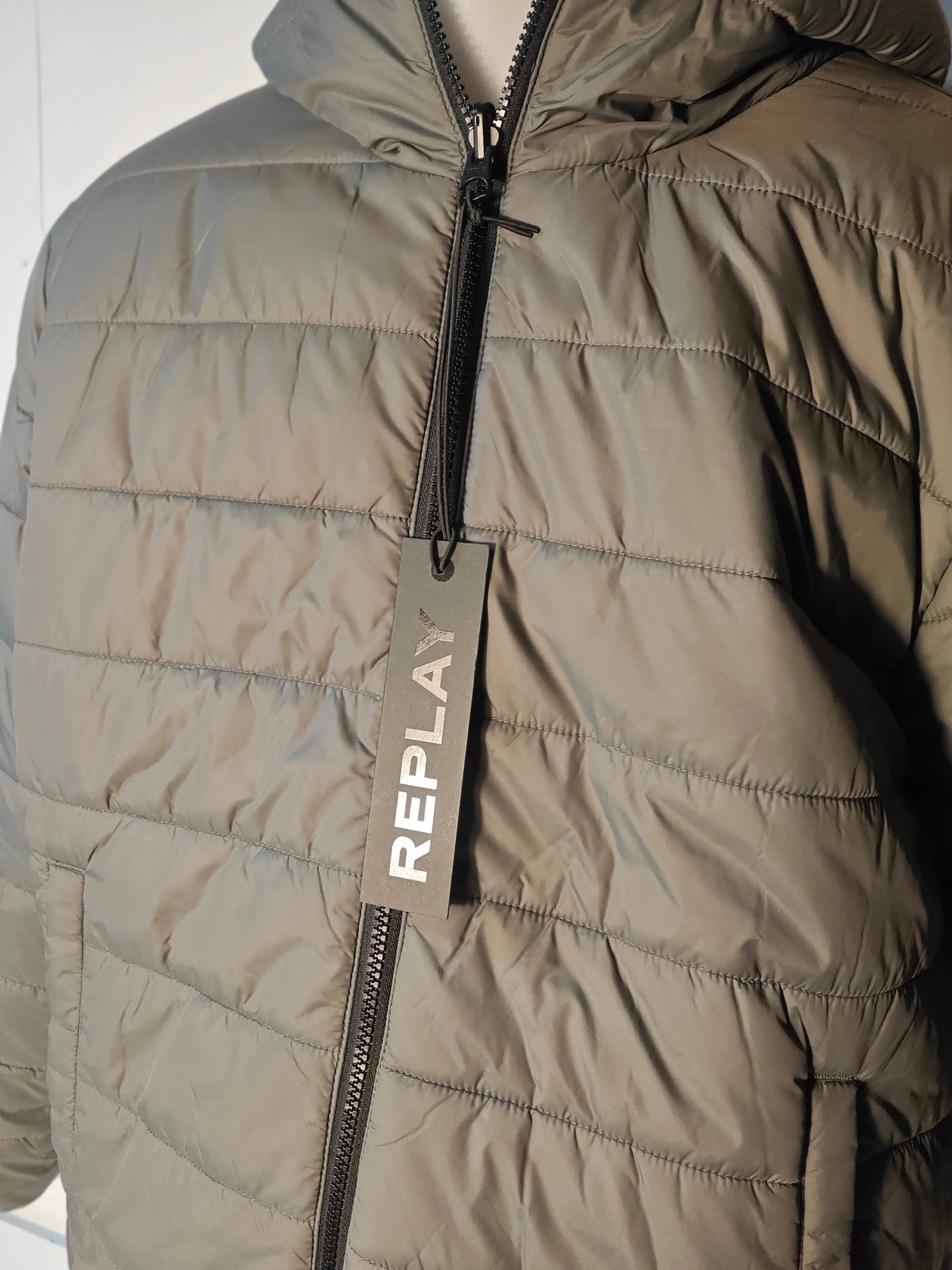 Veste matelassée kaki réversible par Replay, avec fermeture éclair visible et étiquette de marque.