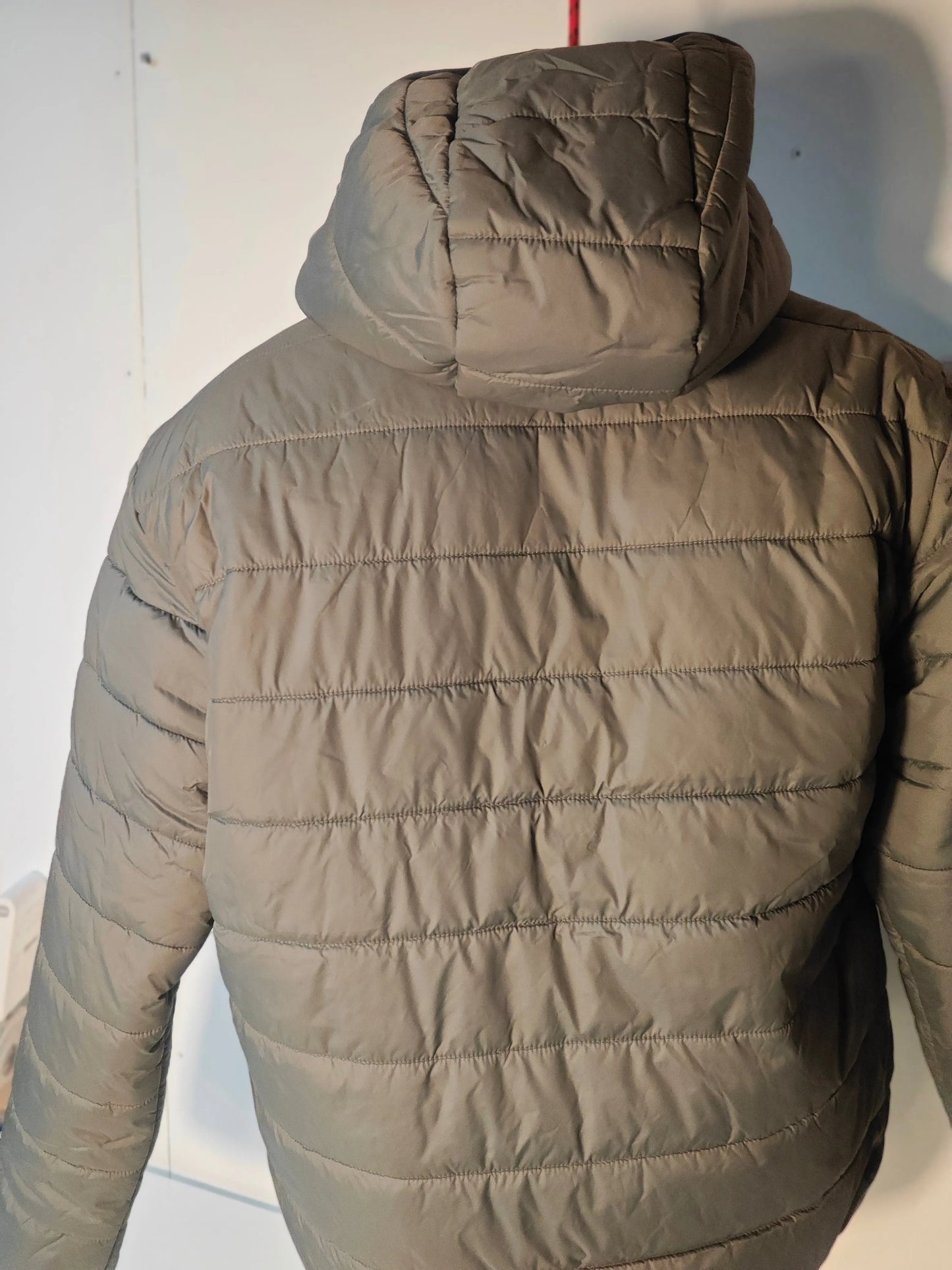 Veste réversible kaki avec capuche de Replay, matelassée avec coutures horizontales, présentée de dos.