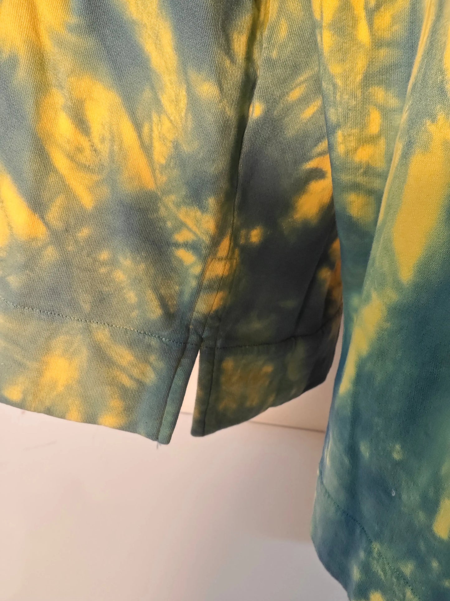 Sweat à capuche Sandro tie and dye bleu et jaune, avec ourlet fendu.
