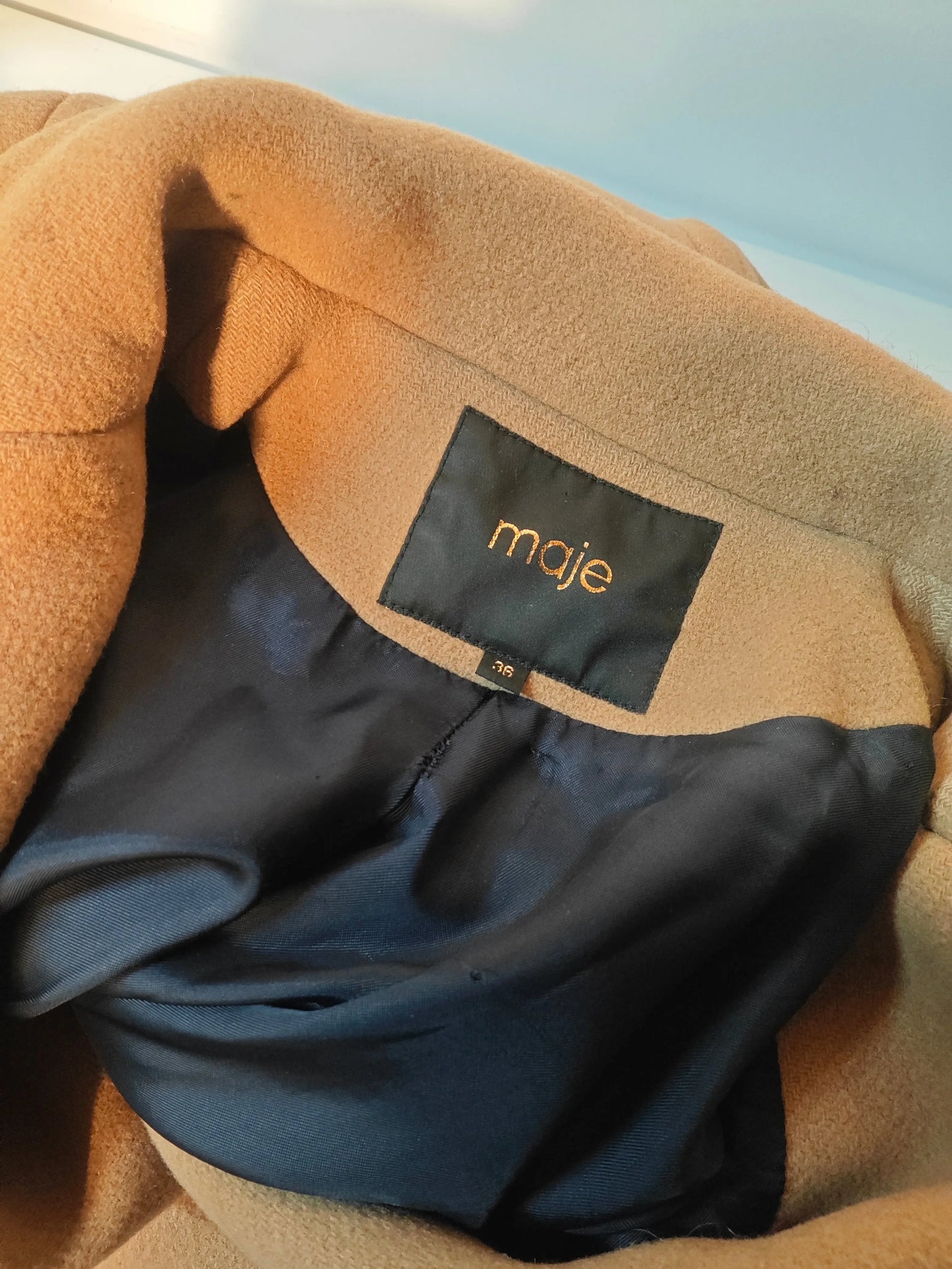 Manteau camel à double boutonnage by Maje, montrant l'intérieur avec l'étiquette de la marque et la taille.