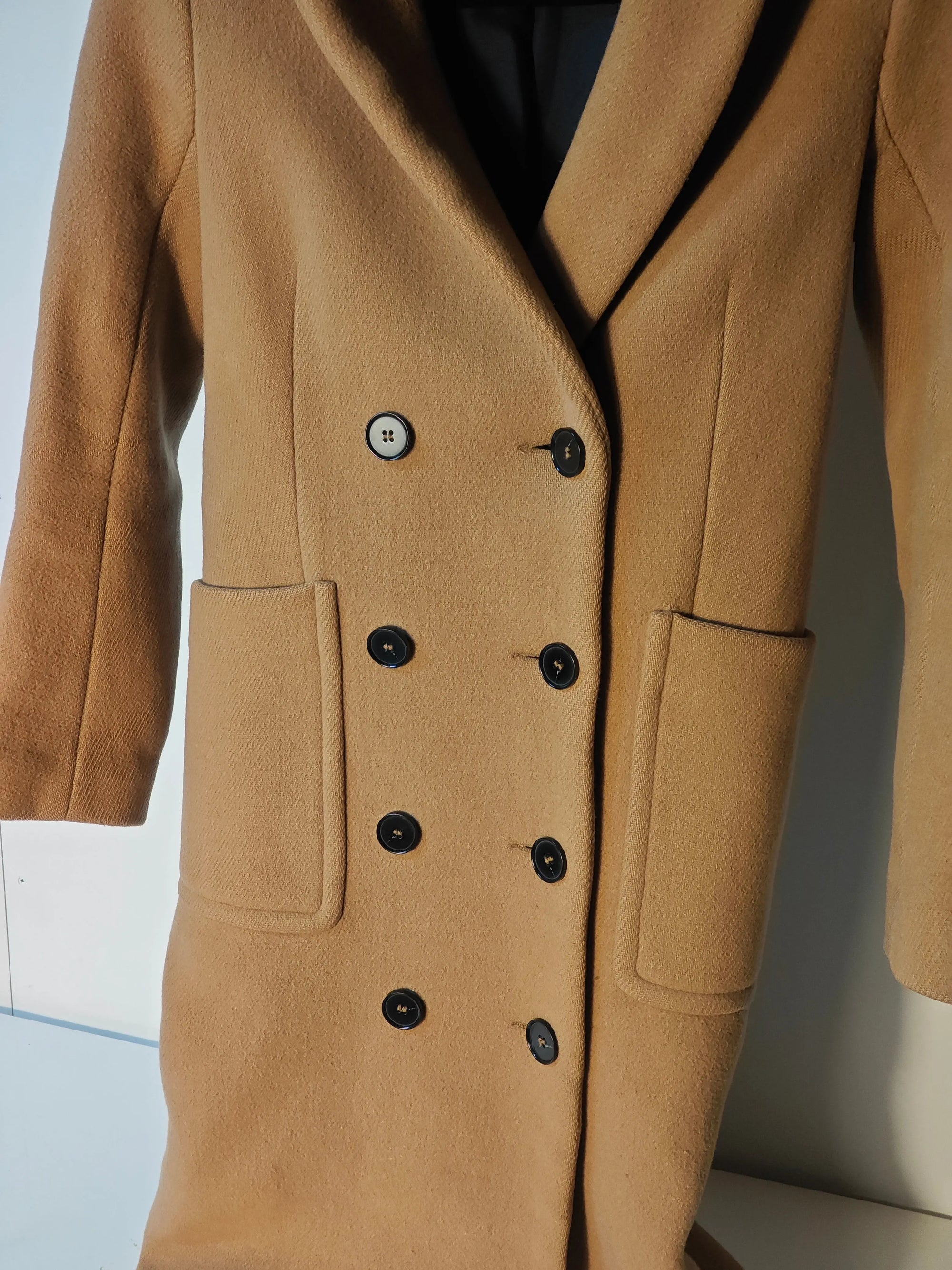 Manteau camel long de Maje, coupe croisée à double boutonnage et poches plaquées.