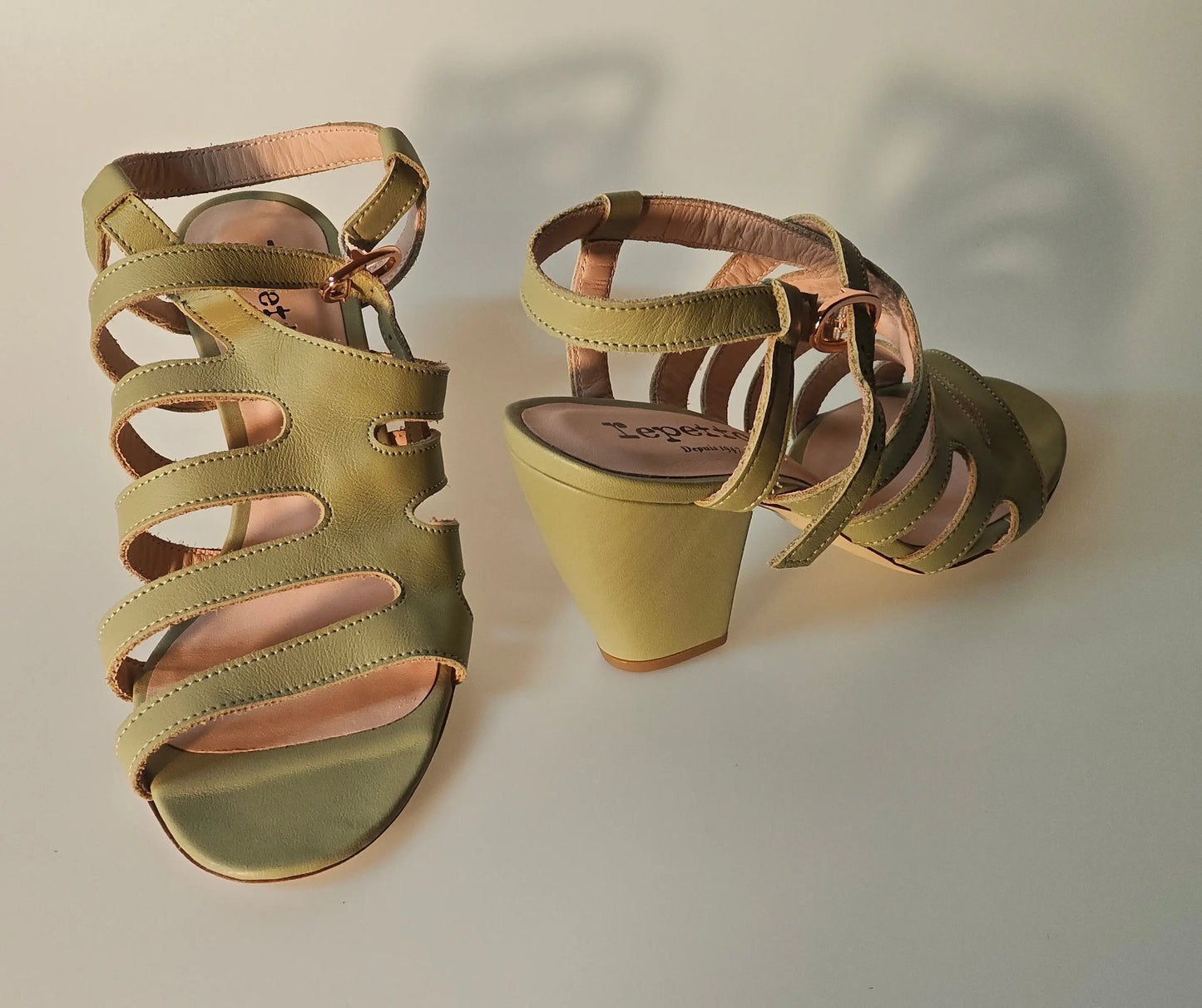 Sandales à talons en cuir vert olive de Repetto, avec découpes décoratives et brides ajustables.
