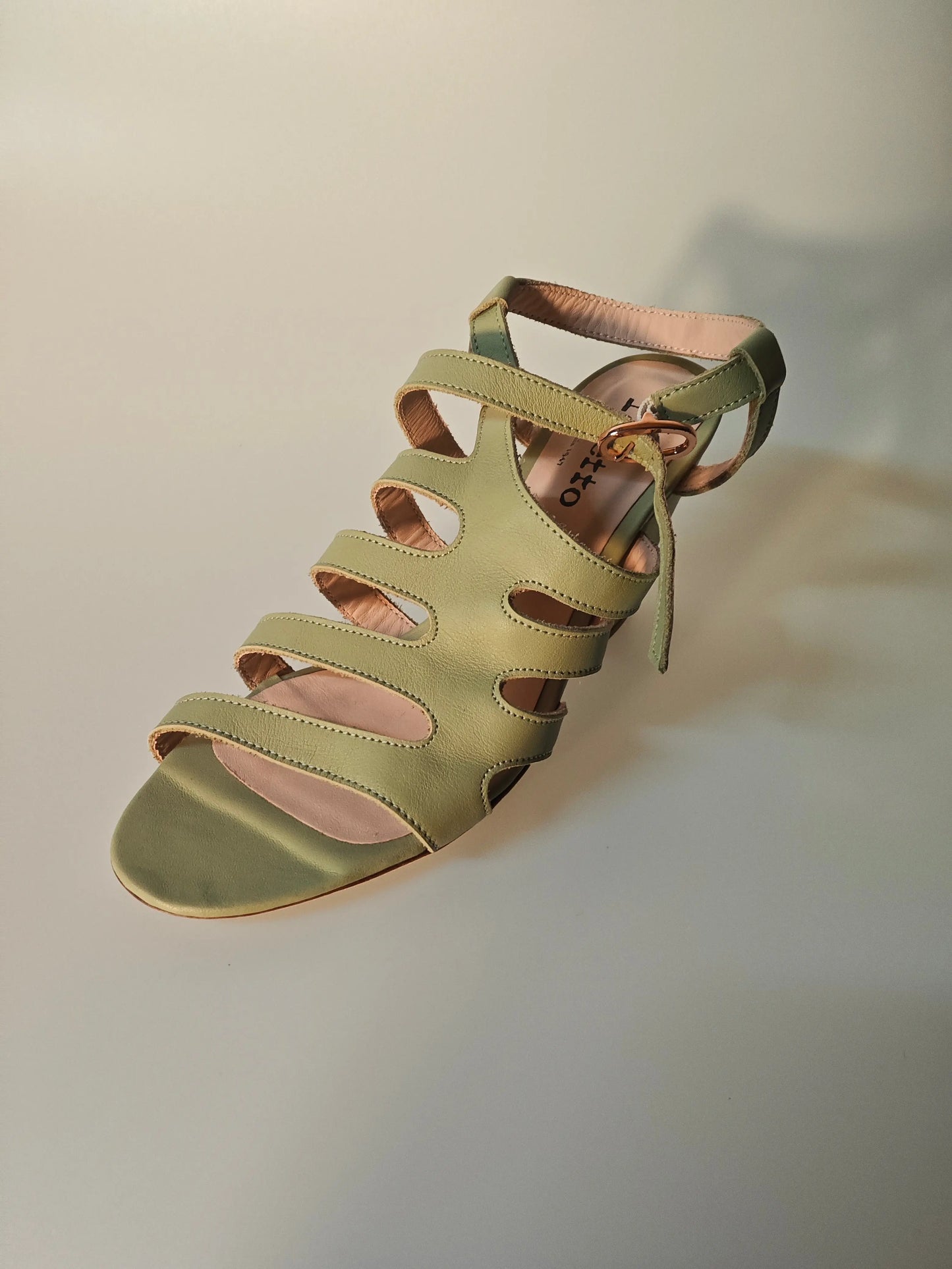 Sandale en cuir vert olive de Repetto, avec bride cheville et découpes ajourées.
