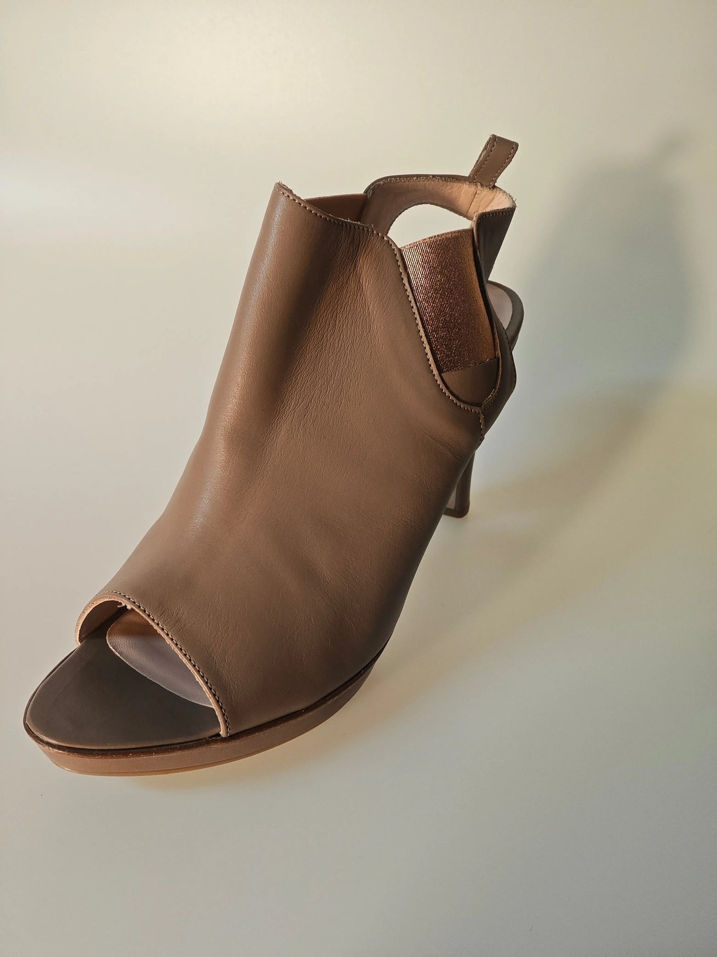 Sandale à talon en cuir marron clair de Repetto, avec élastique pailleté.
