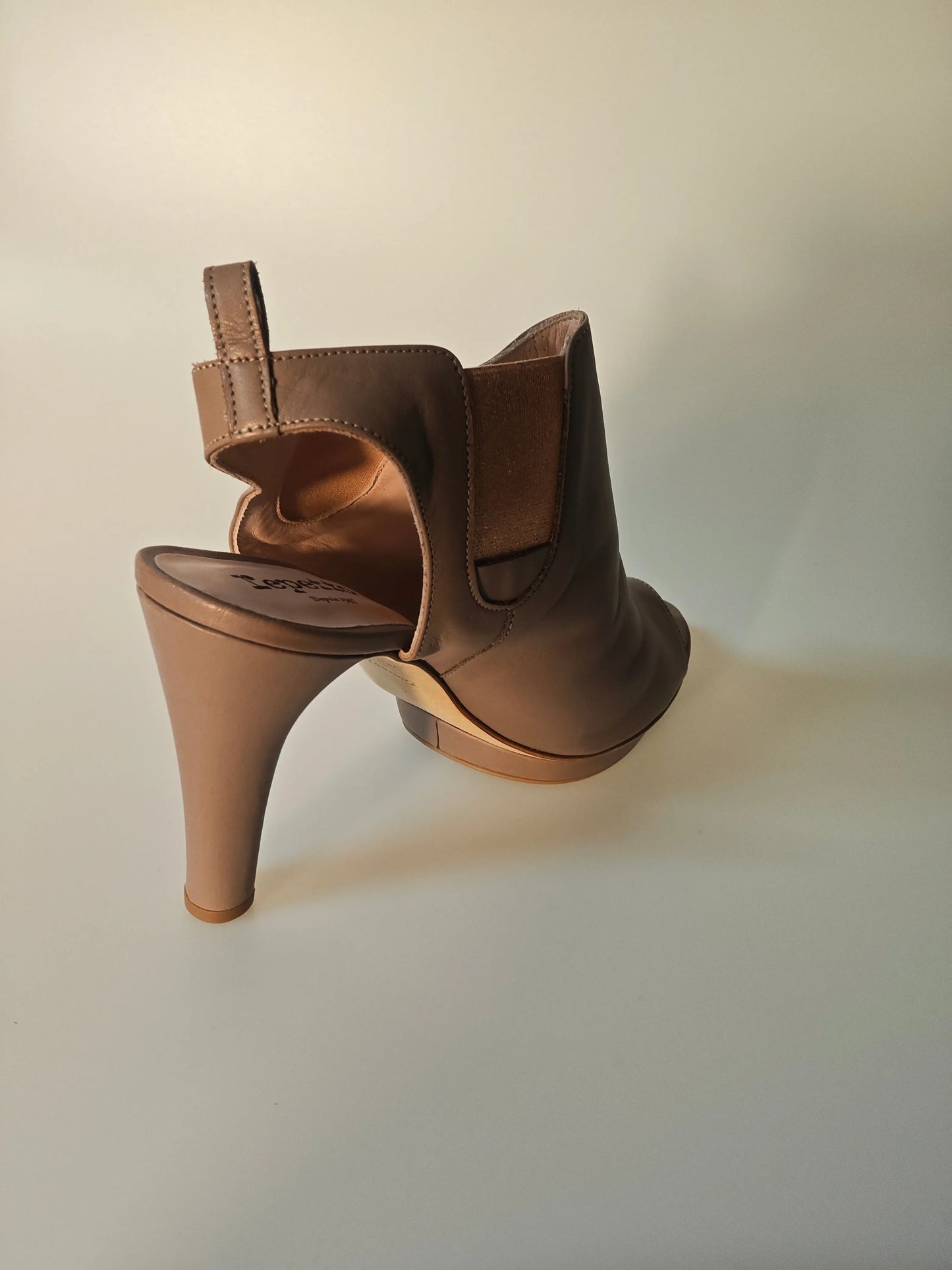 Bottine ouverte en cuir beige de Repetto, avec talon aiguille et élastique sur le côté.
