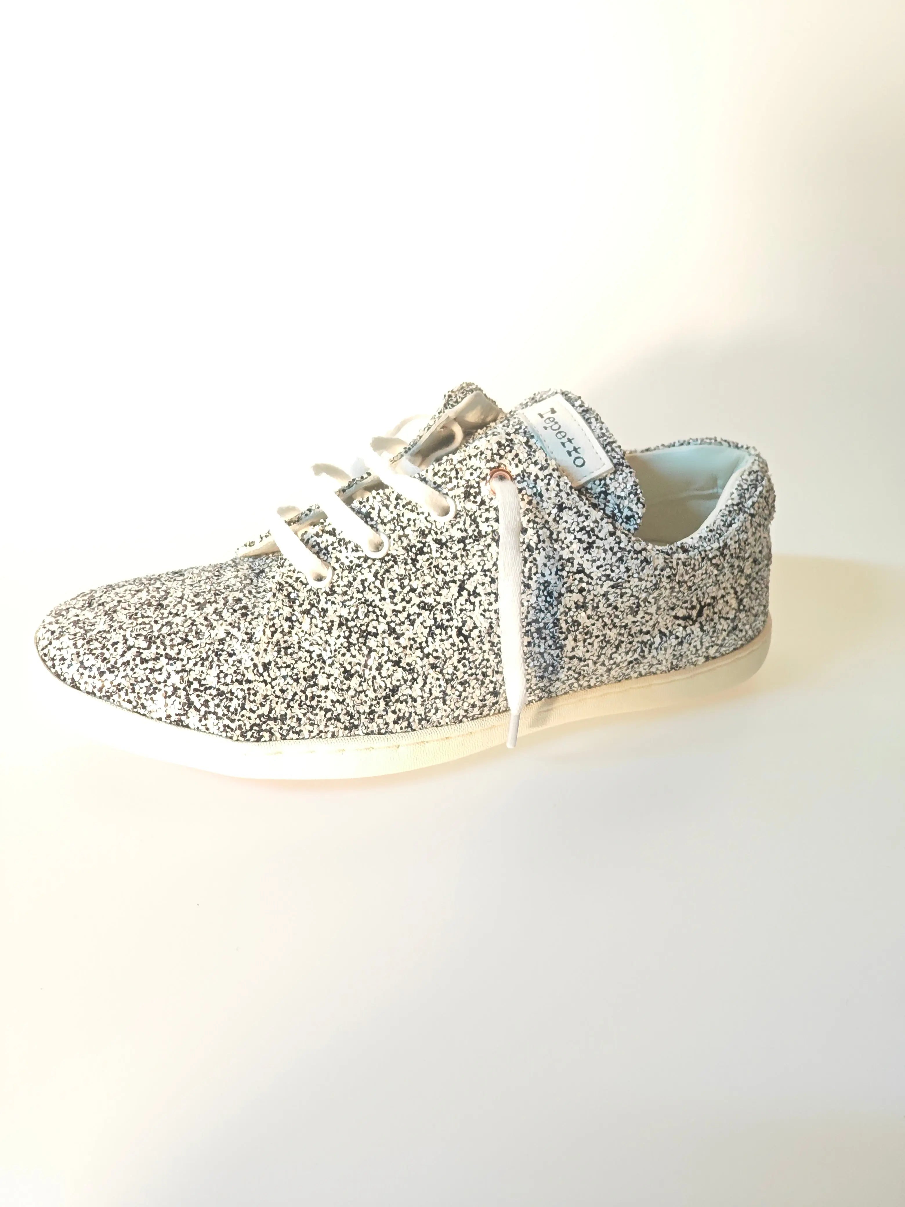 Baskets à paillettes blanches et noires de Repetto, avec lacets blancs et semelle blanche.
