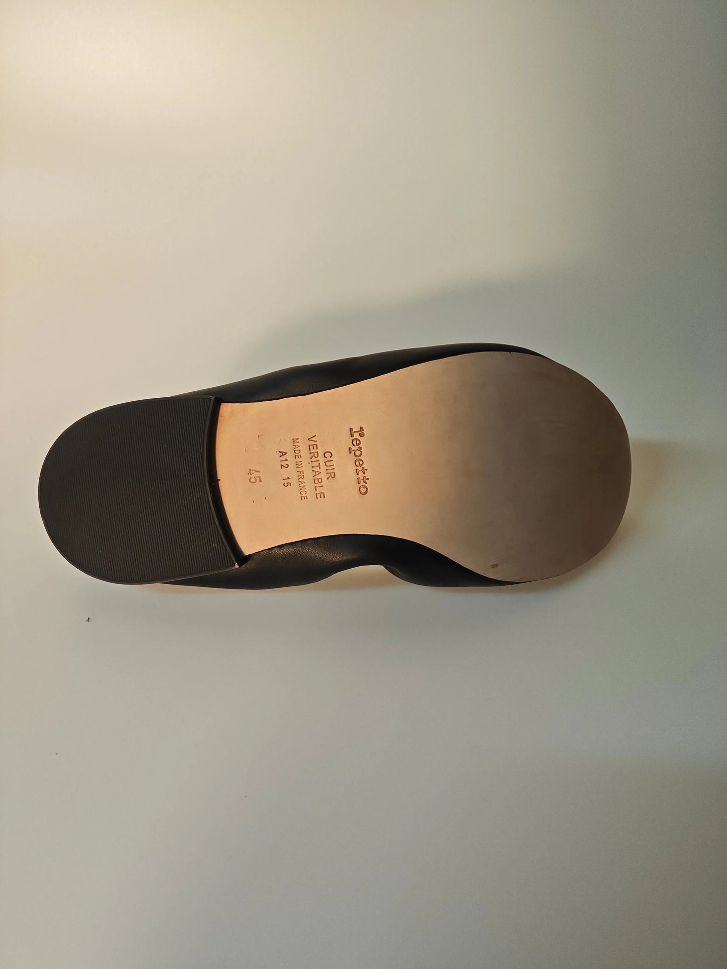 Ballerine noire en cuir, de Repetto, avec semelle en cuir lisse et contrefort en caoutchouc.
