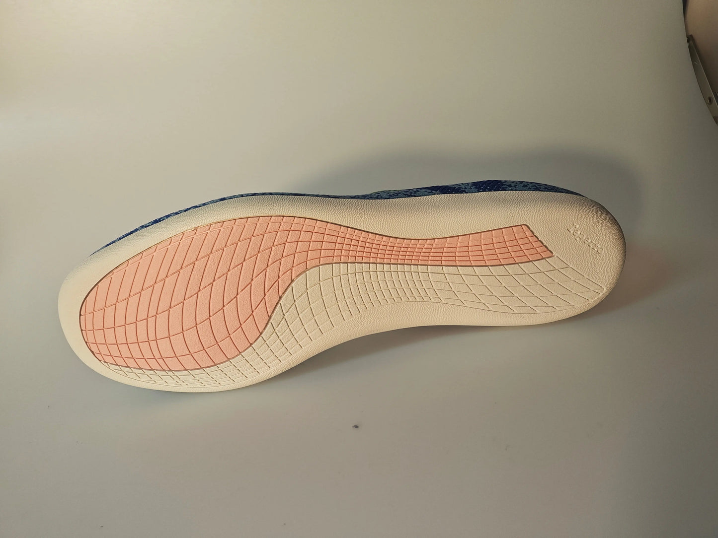 Semelle de chaussure de sport rose et crème de Repetto, avec motifs texturés quadrillés.
