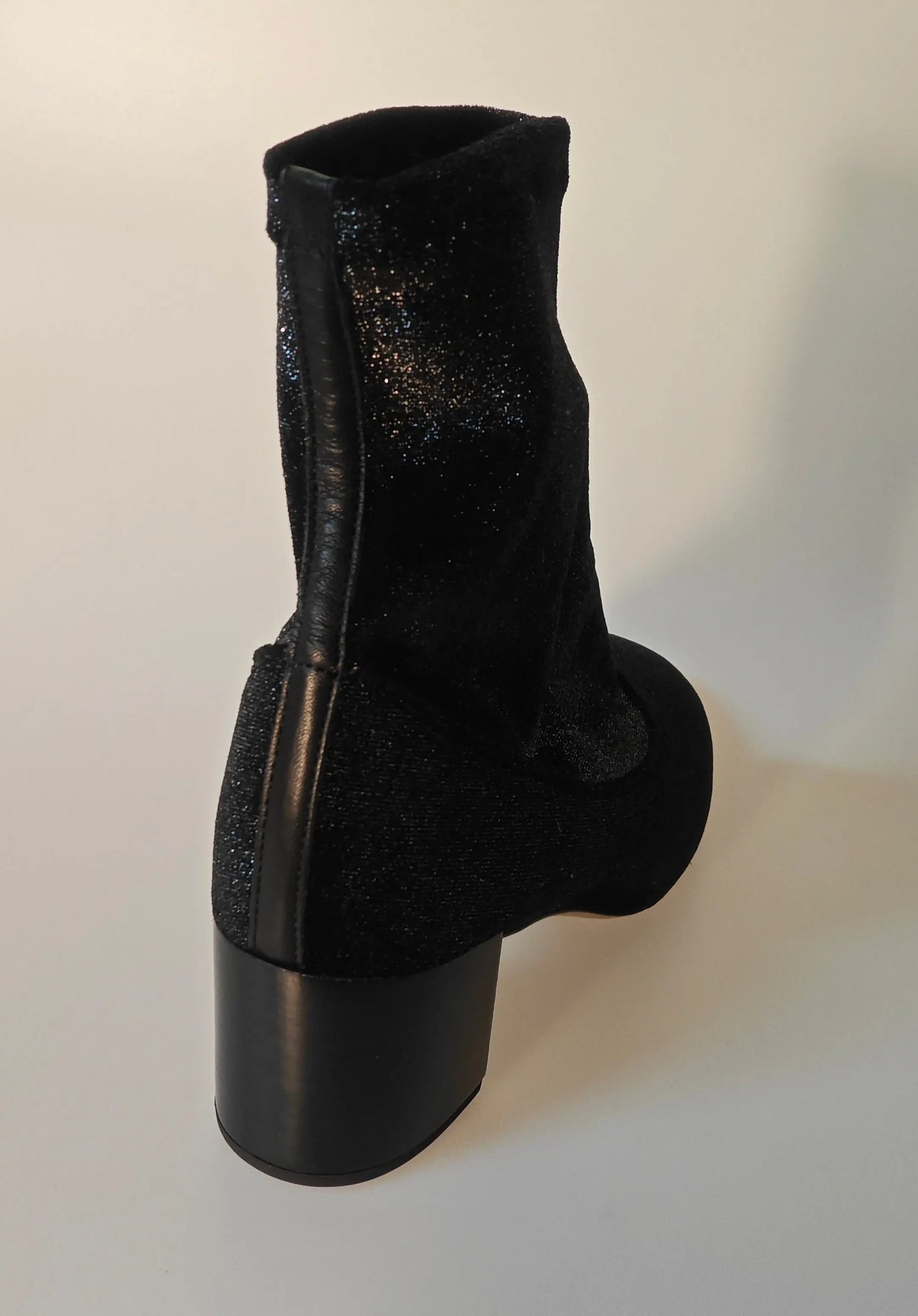 Bottine Ingrid noire de Repetto, avec un effet scintillant et un talon bloc structuré.
