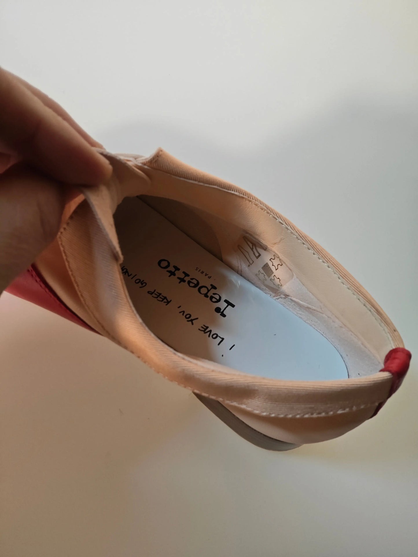 Ballerine en cuir rouge et nude de Repetto avec inscription à l'intérieur.

