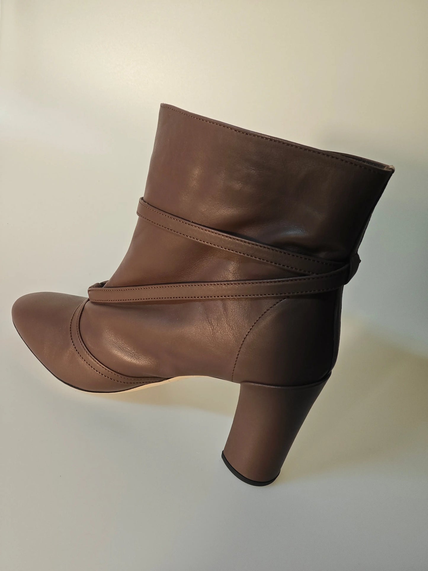 Bottines en cuir marron Repetto, avec brides croisées décoratives et talon bottier cylindrique.