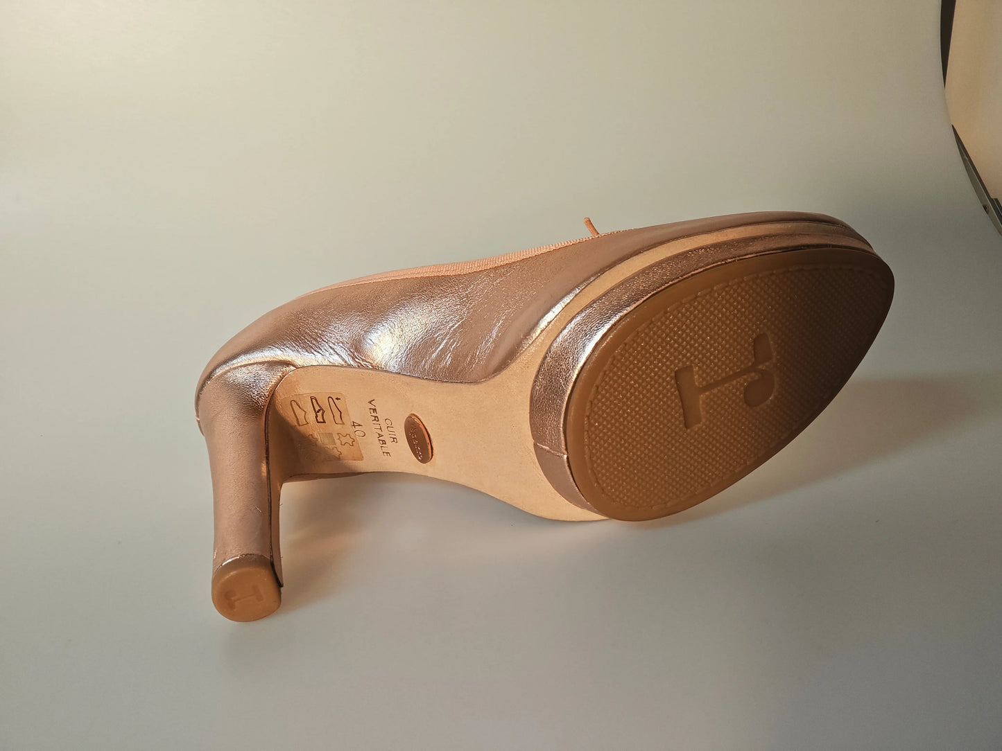 Escarpin en cuir rose cuivré par Repetto, semelle ton sur ton marquée d'un logo et talon cylindrique.
