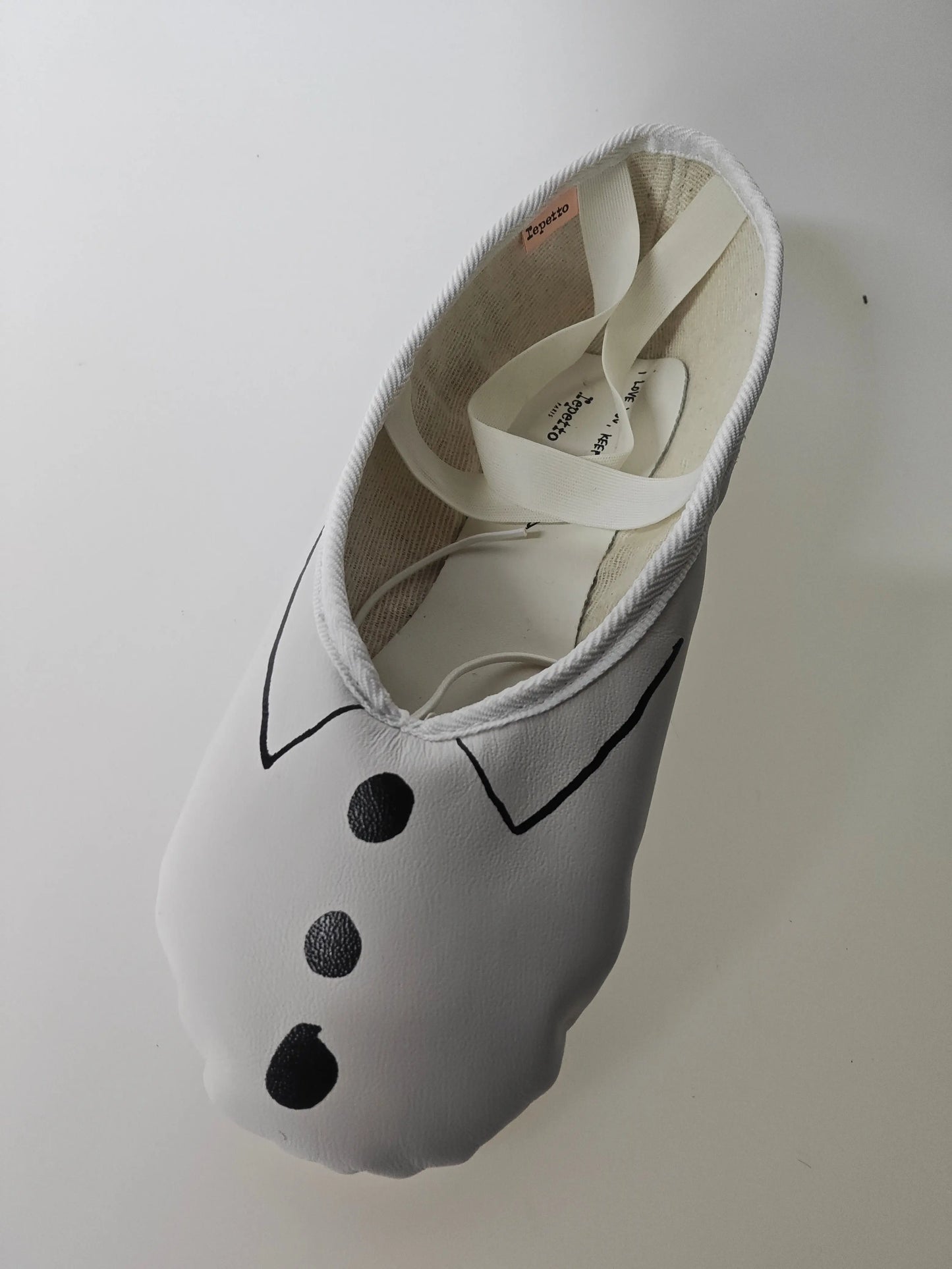 Ballerine blanche à motif smoking de Repetto avec des lacets blancs.