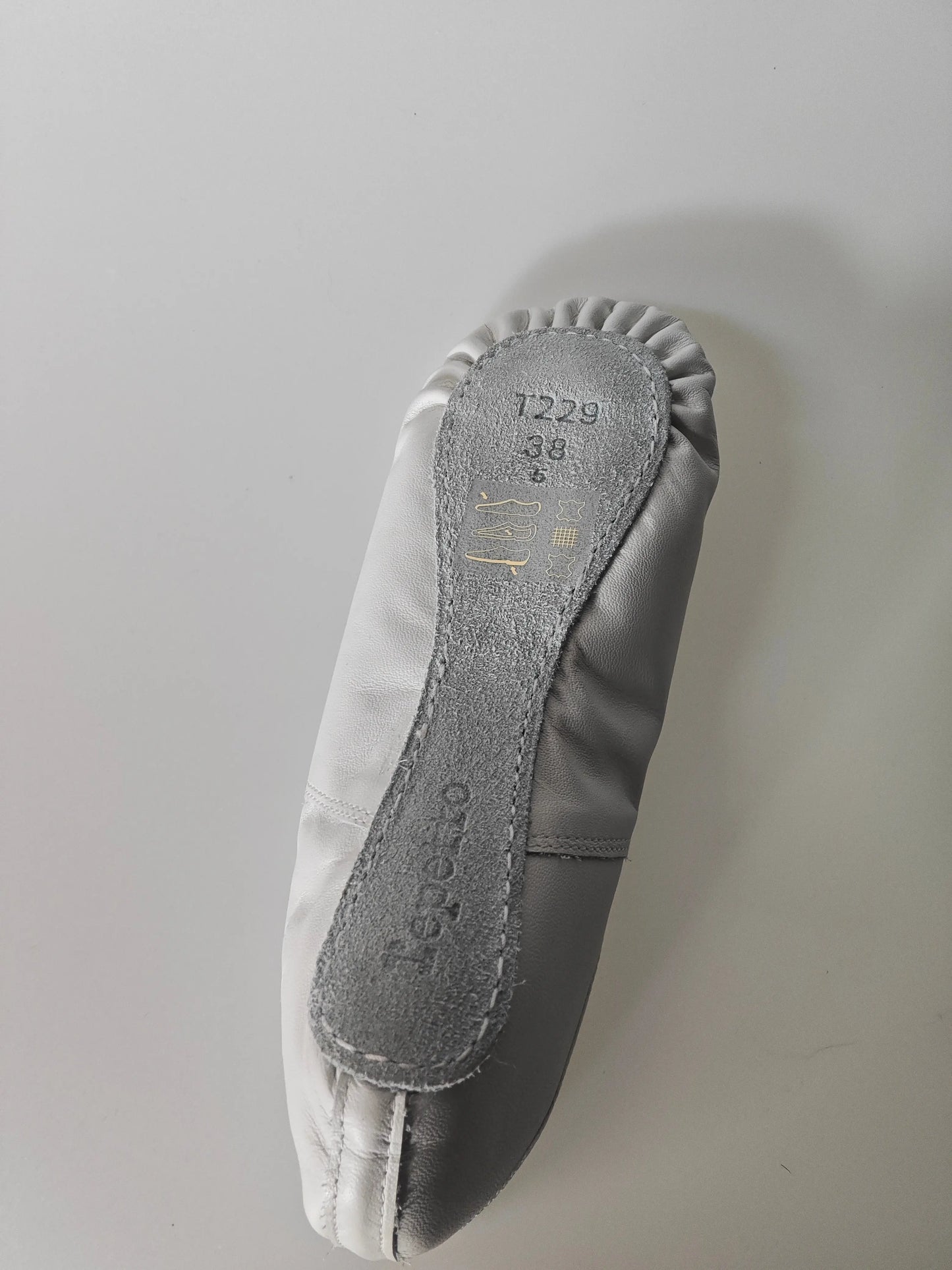Chausson de danse gris et blanc de Repetto, avec semelle en daim et plis sur le bord.