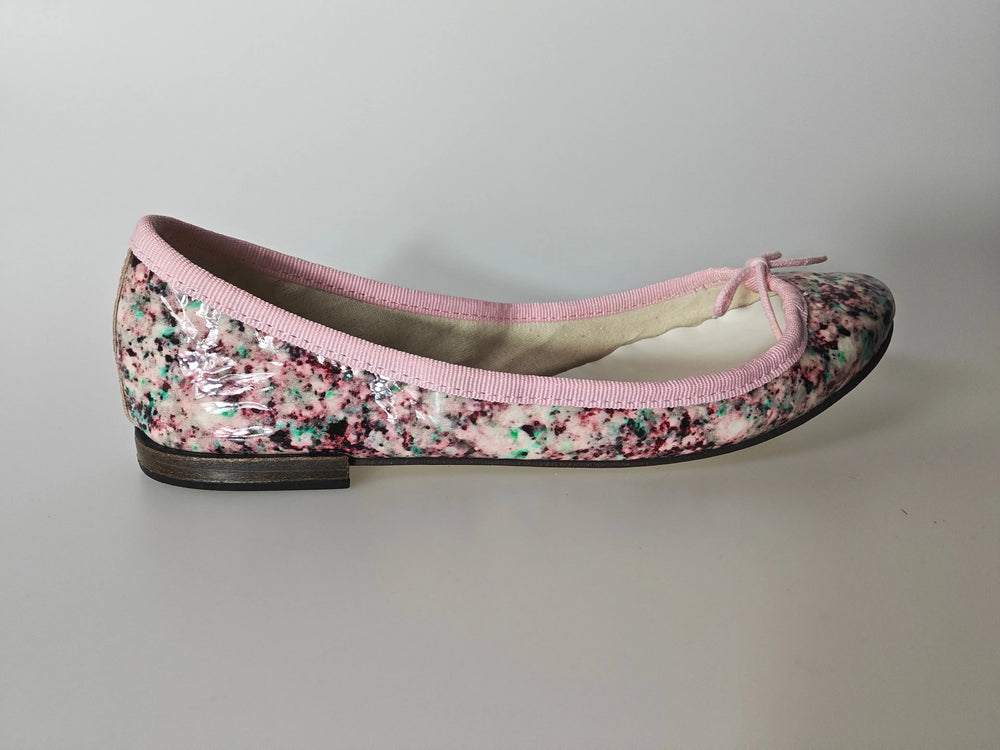 Ballerine vernie multicolore de Repetto, avec liseré rose et petit noeud décoratif.