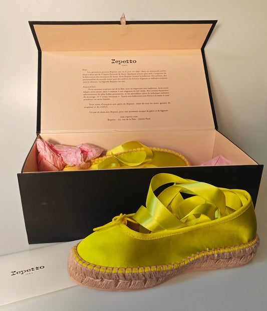 Espadrilles jaunes en satin, de Repetto, avec rubans jaune vif et semelle en corde tressée.
