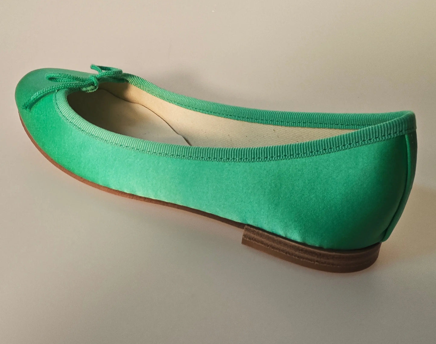 Ballerine verte émeraude en satin de Repetto, avec nœud décoratif et bordure gros-grain.
