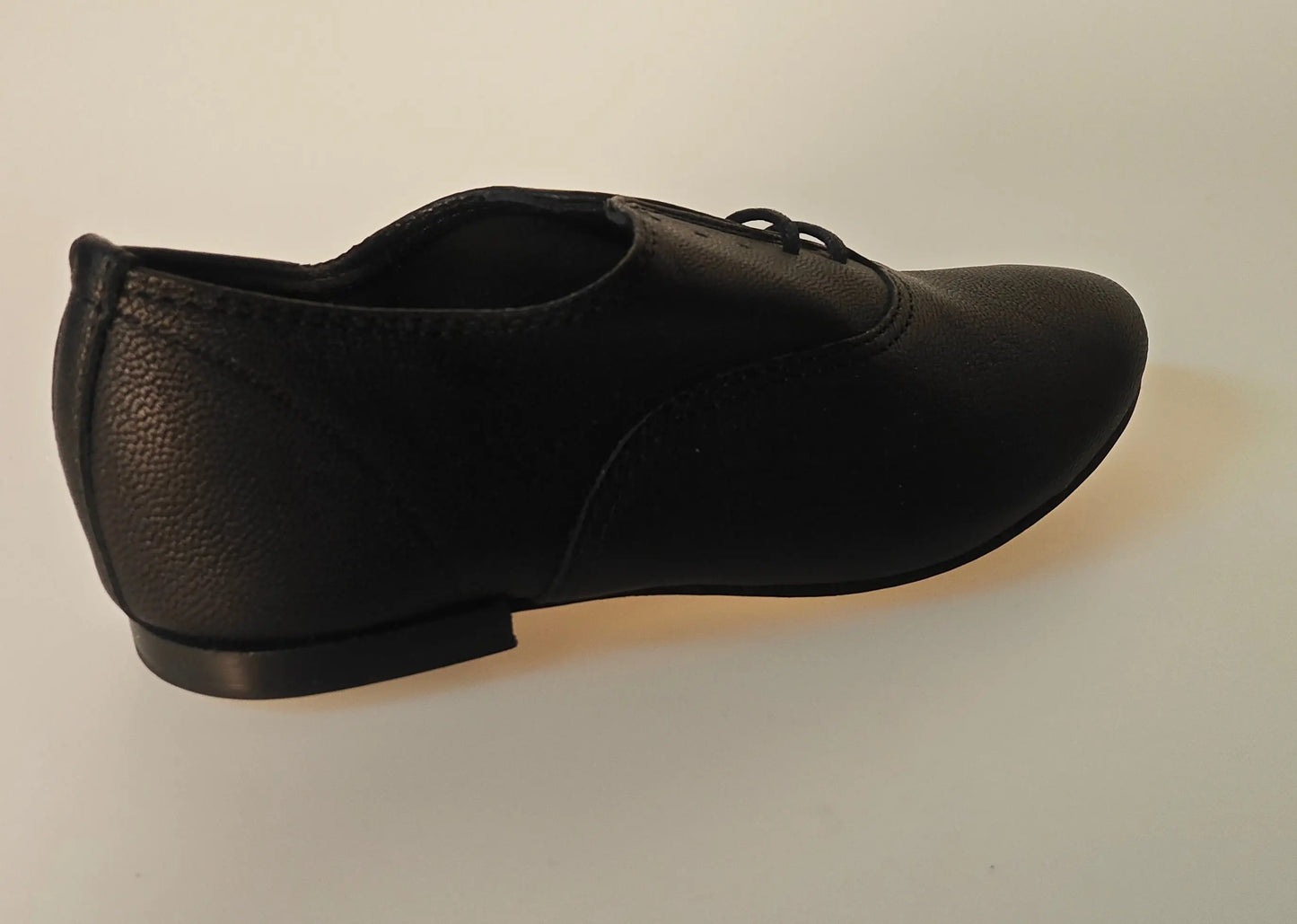 Chaussure Richelieu en cuir noir Repetto, avec lacets et semelle plate, en vue de côté.
