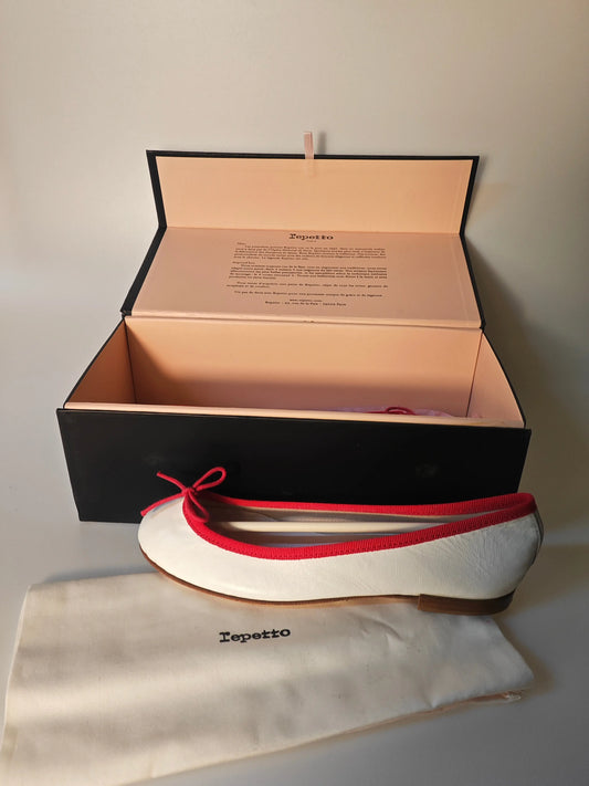 Ballerines blanches en cuir avec bordure rouge, par Repetto, présentées avec leur sac et boîte d'origine.
