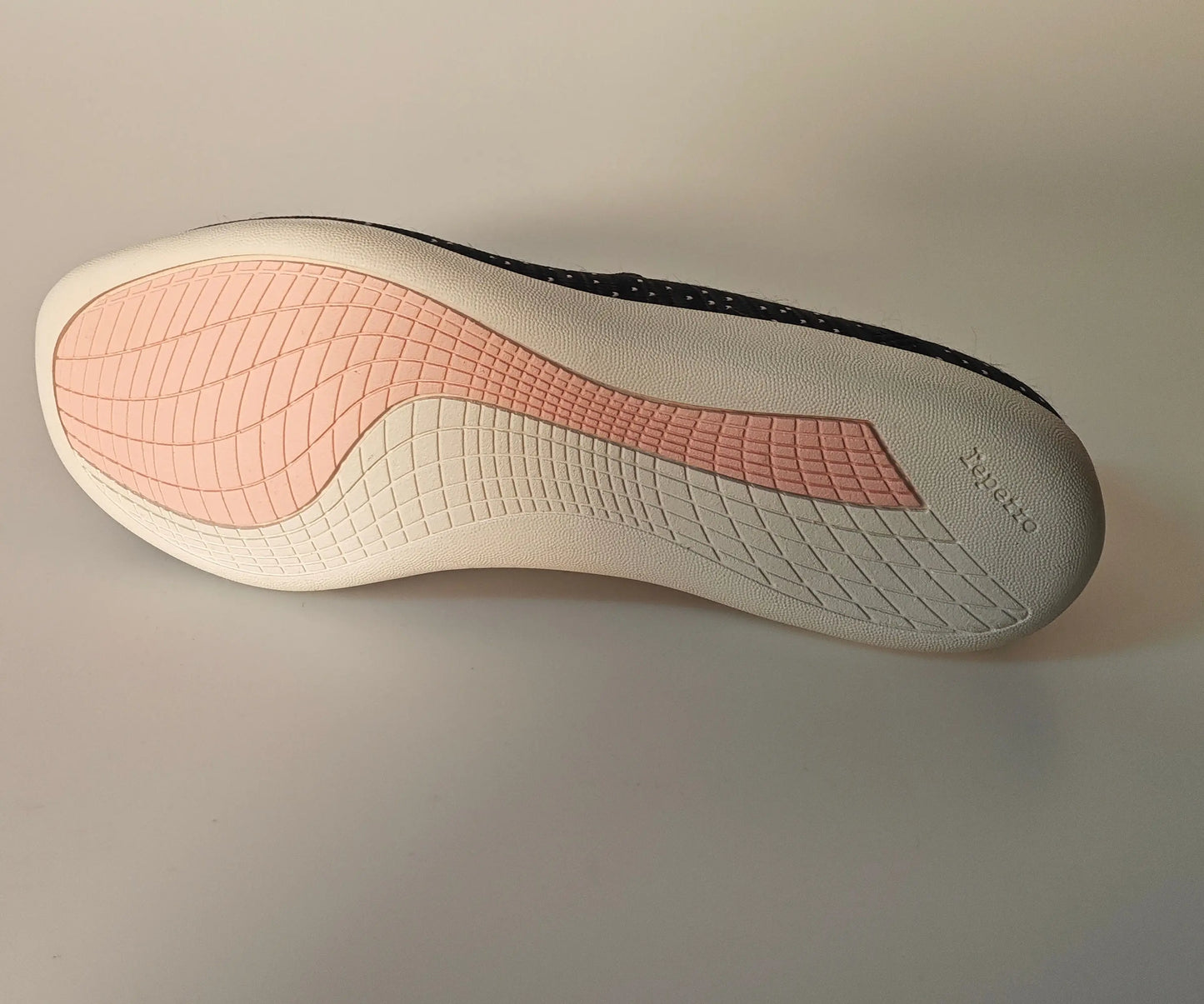 Sneaker noire à pois blancs de Repetto avec semelle rose et crème texturée, vue de dessous.
