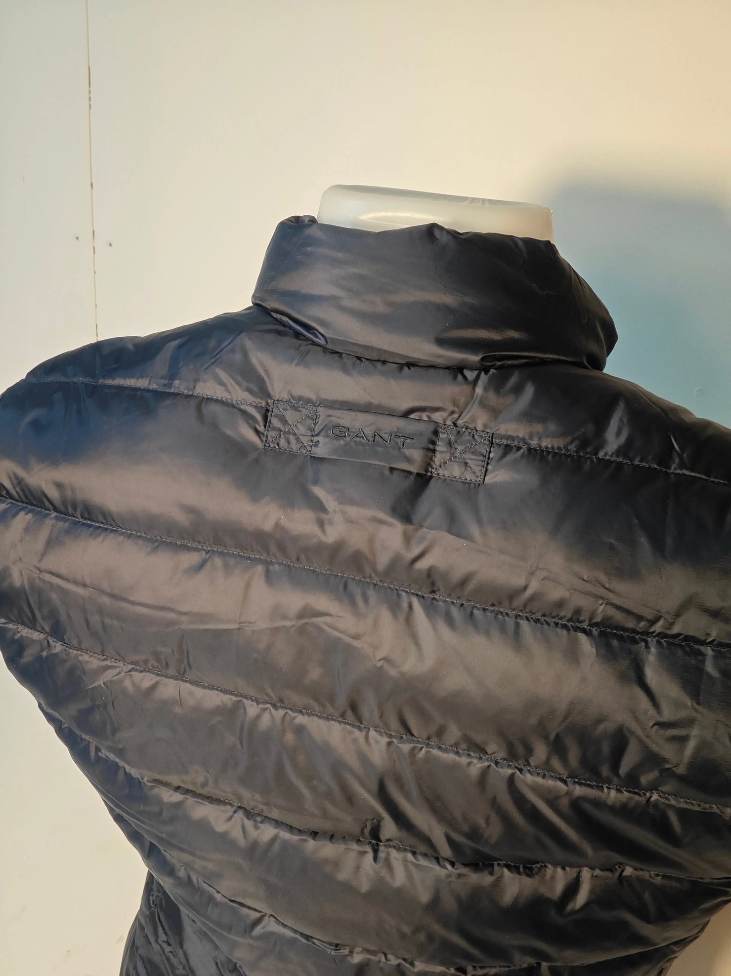 Doudoune sans manches bleu marine de Gant, détail du logo brodé sur le haut du dos, rembourrage matelassé.