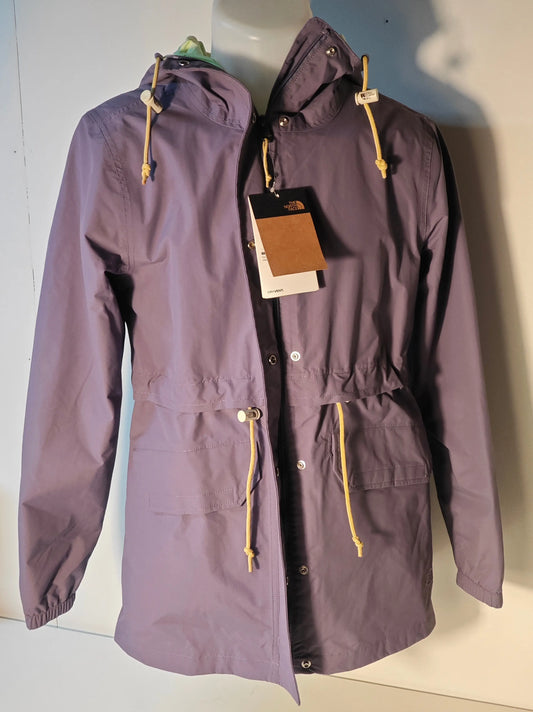 Veste parka violet lavande par The North Face, avec cordon couleur crème et capuche doublée vert menthe.

