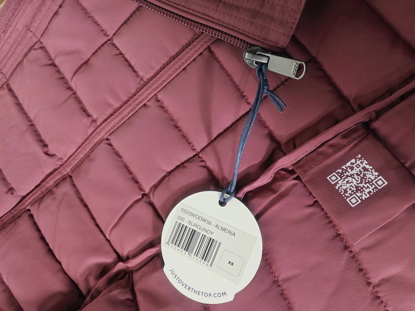 Veste matelassée bordeaux pour femme de Jott, avec fermeture éclair apparente et motif géométrique.