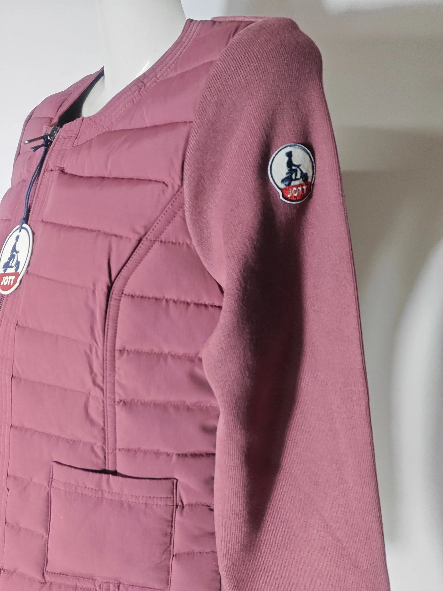 Veste matelassée bordeaux ALMEIRA de Jott, avec manches en tricot côtelé et logo rond sur la manche.