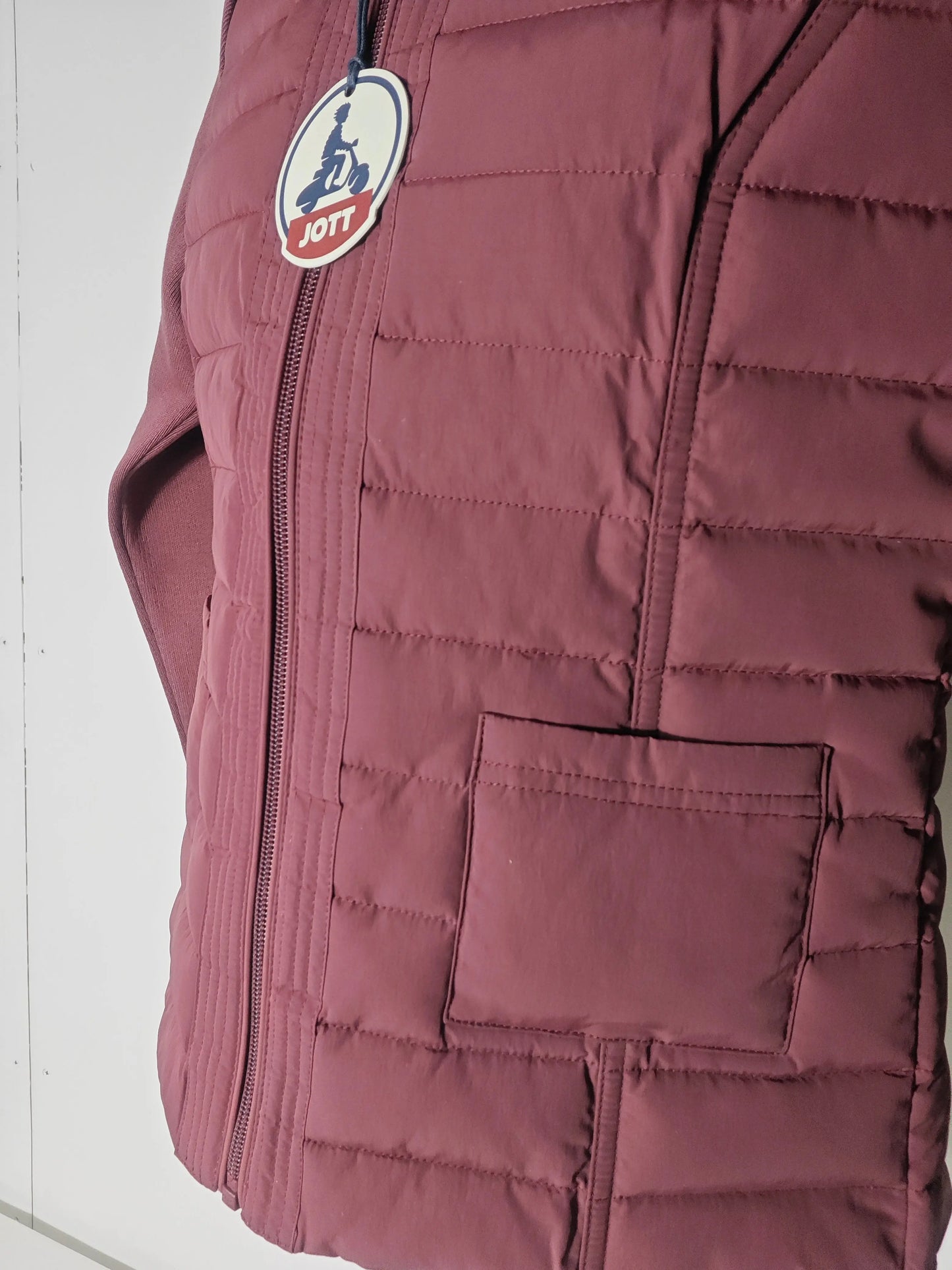 Veste matelassée bordeaux de Jott, avec manches en maille et poche plaquée.