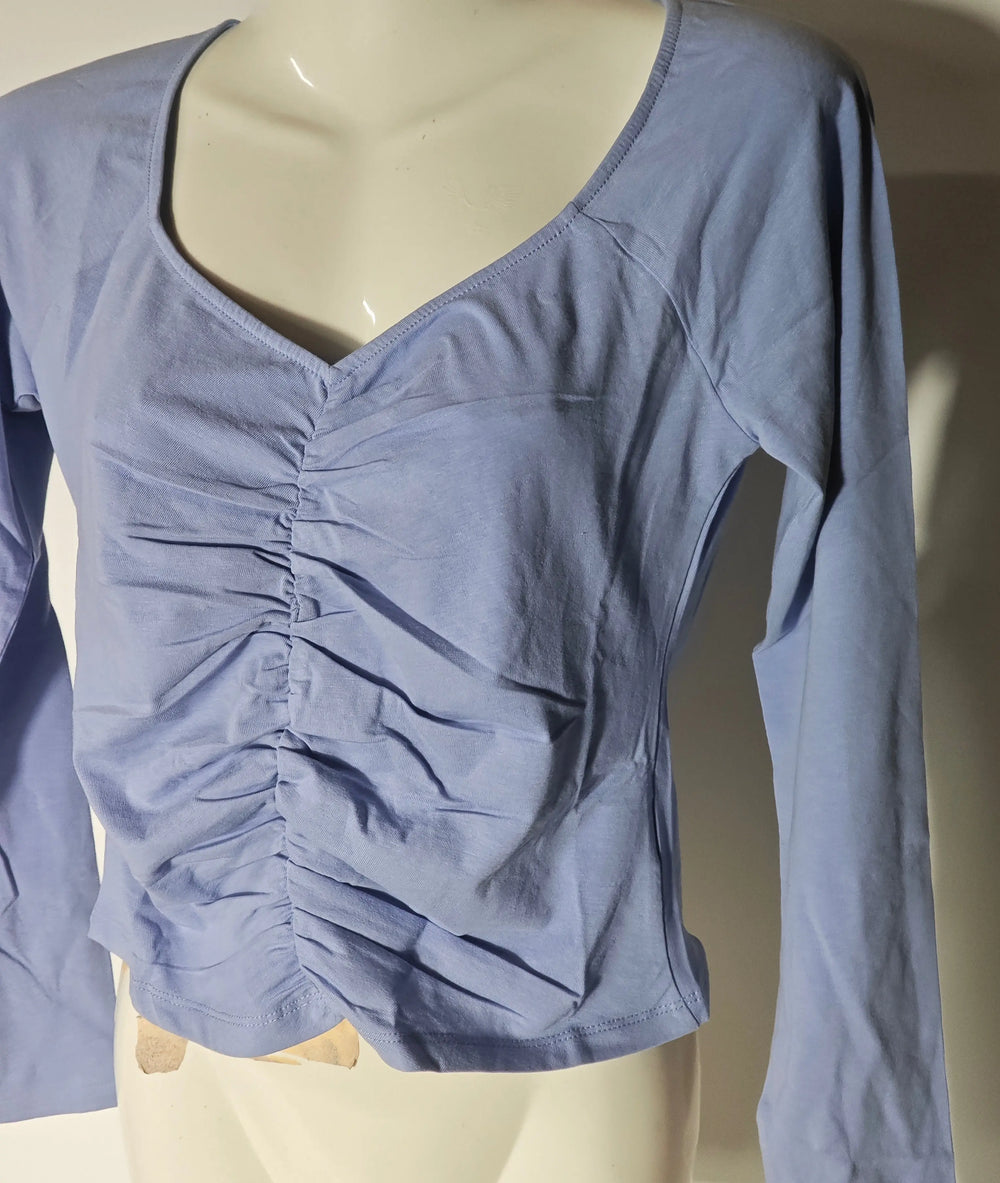 Haut bleu froncé de Monki avec encolure en V et manches longues, présenté sur un mannequin.
