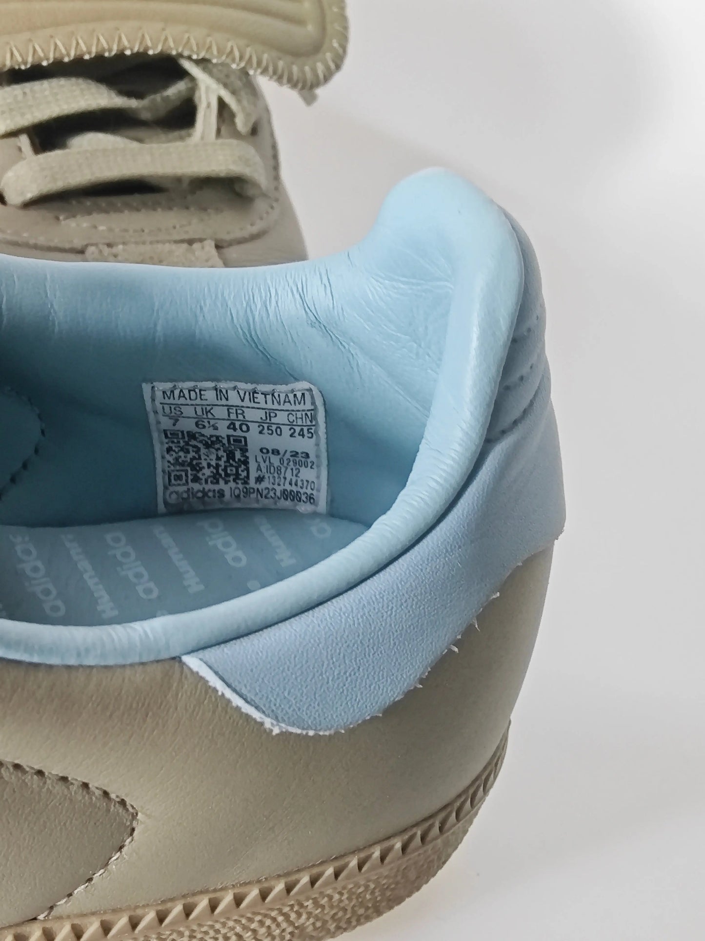 Baskets en cuir beige, par Adidas, avec doublure bleu clair et semelle texturée.
