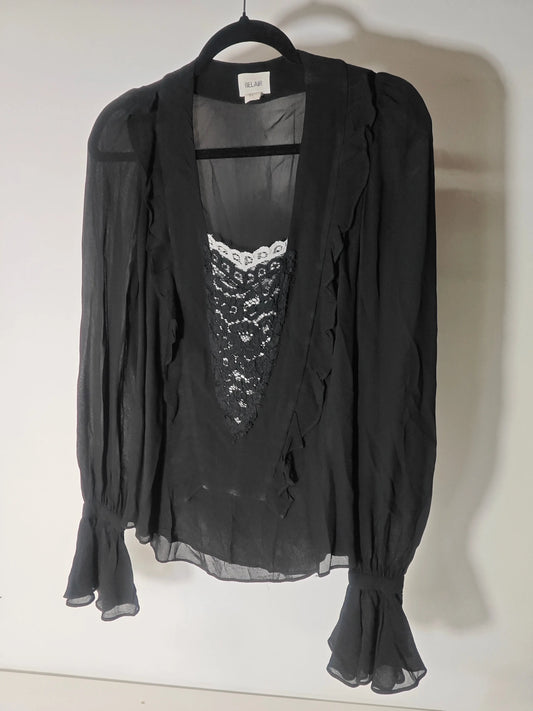 Blouse noire à manches longues par Belair, ornée de dentelle et de volants délicats.