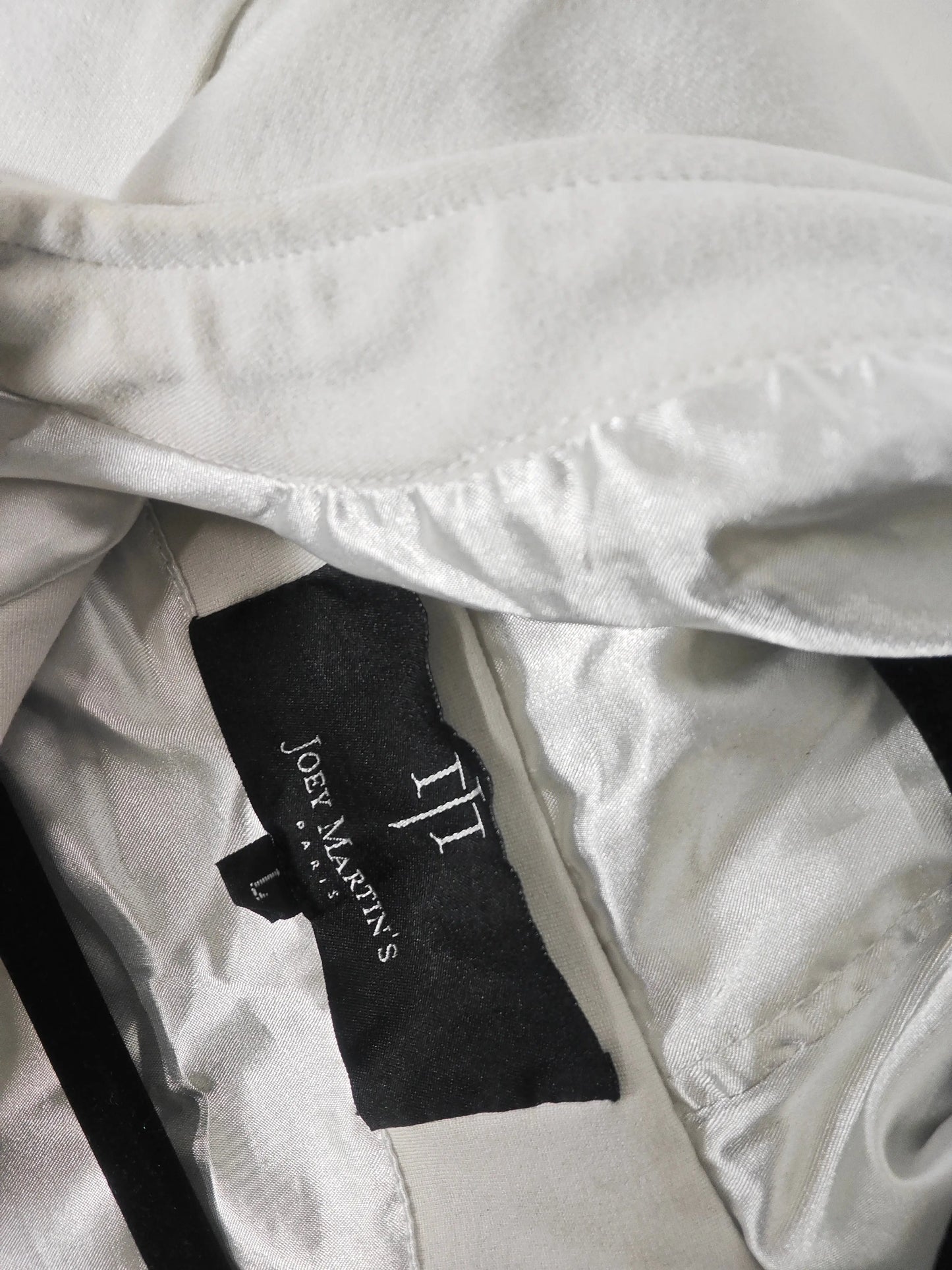 Veste à capuche blanche de Joey Martin’s Paris, avec une doublure brillante et l'étiquette de taille L visible.