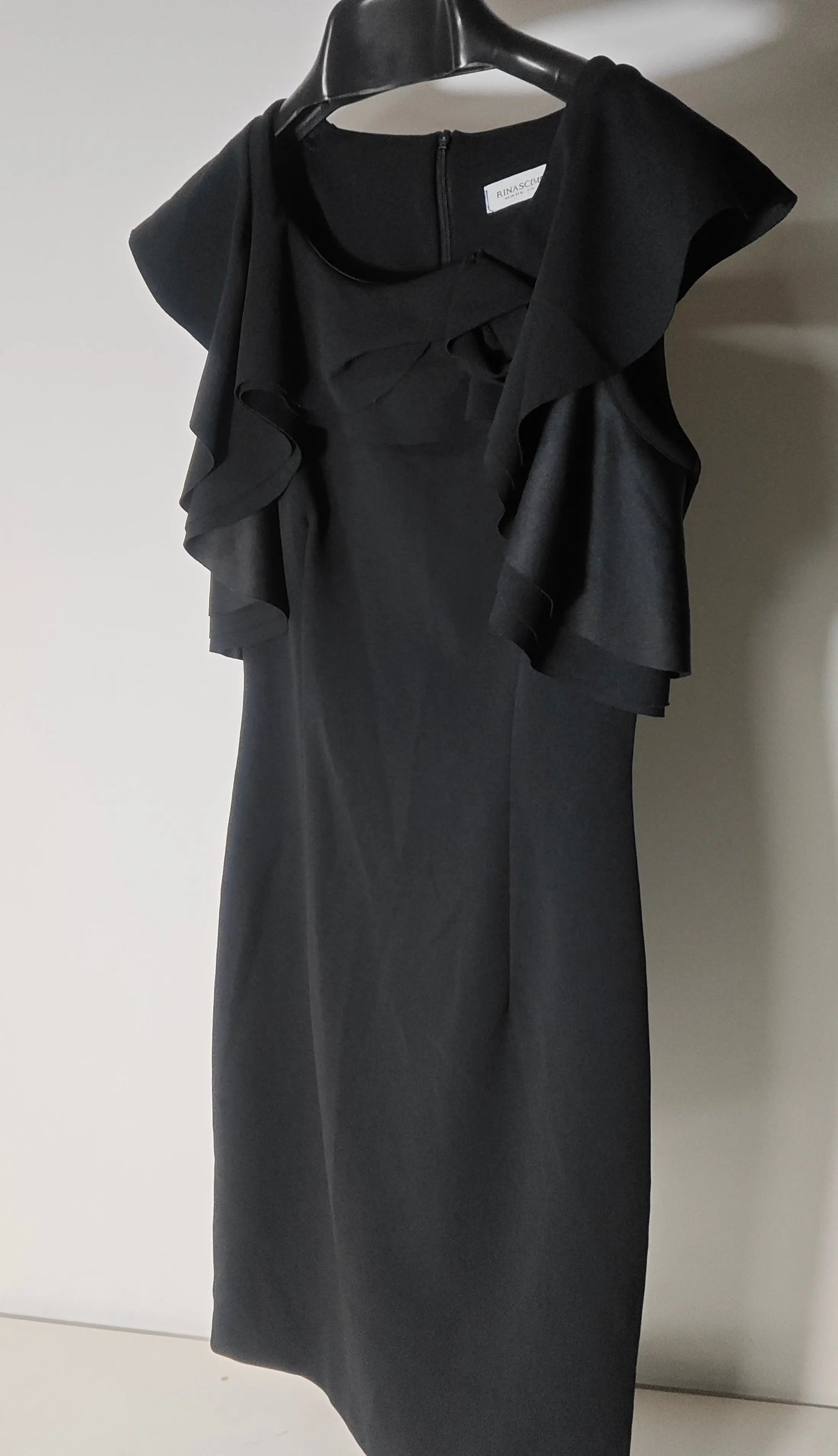 Robe noire élégante à volants de Rinascimento, fabrication italienne, sur un cintre.