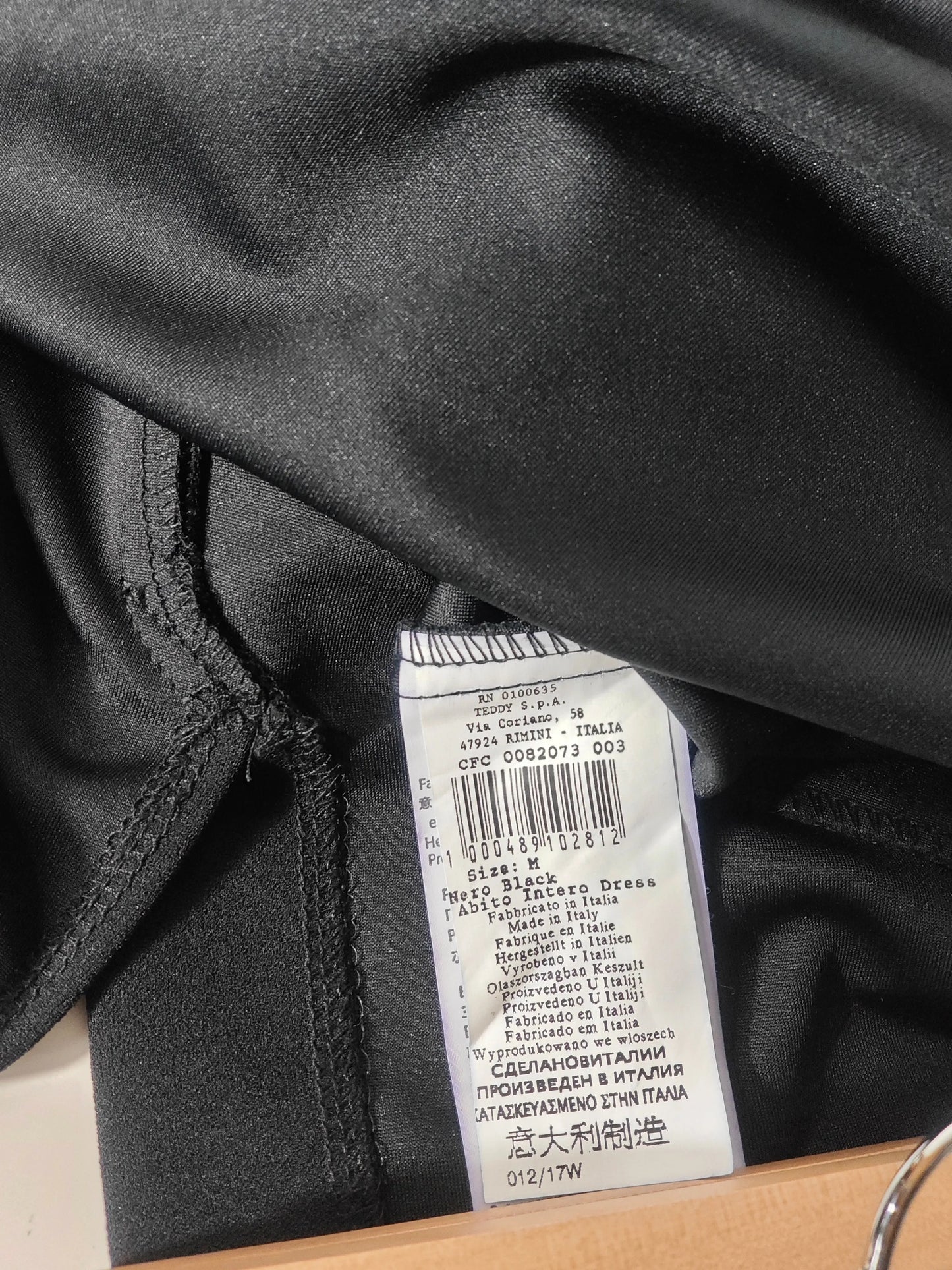 Robe noire élégante à volants de Rinascimento, fabriquée en Italie, avec une étiquette d'entretien apparente.