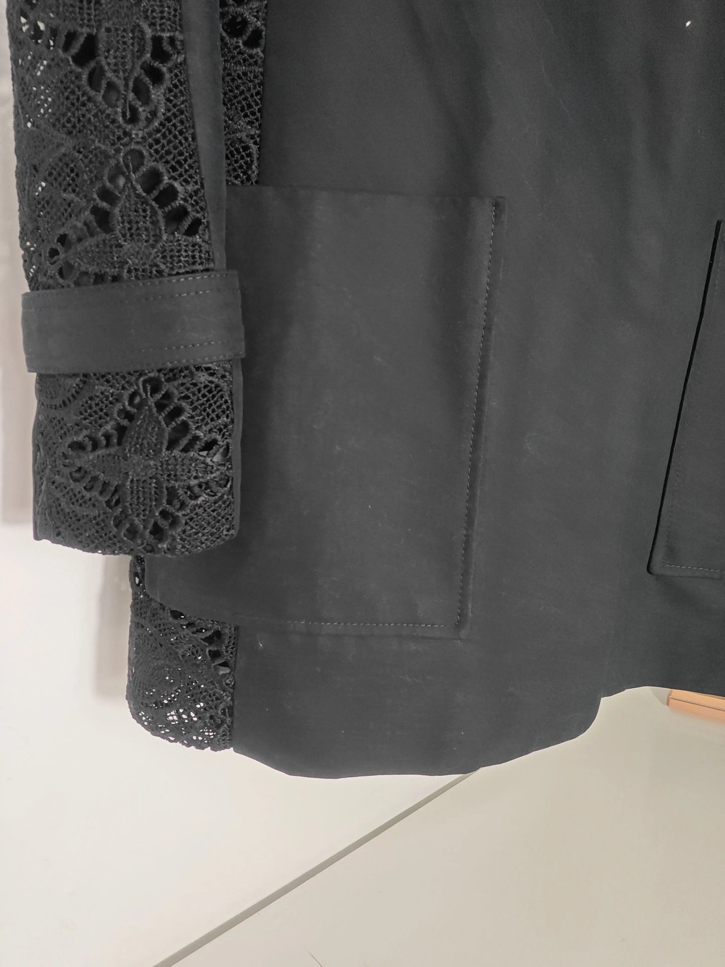 Veste noire à manches en dentelle de Maje, avec poches plaquées et finitions travaillées.